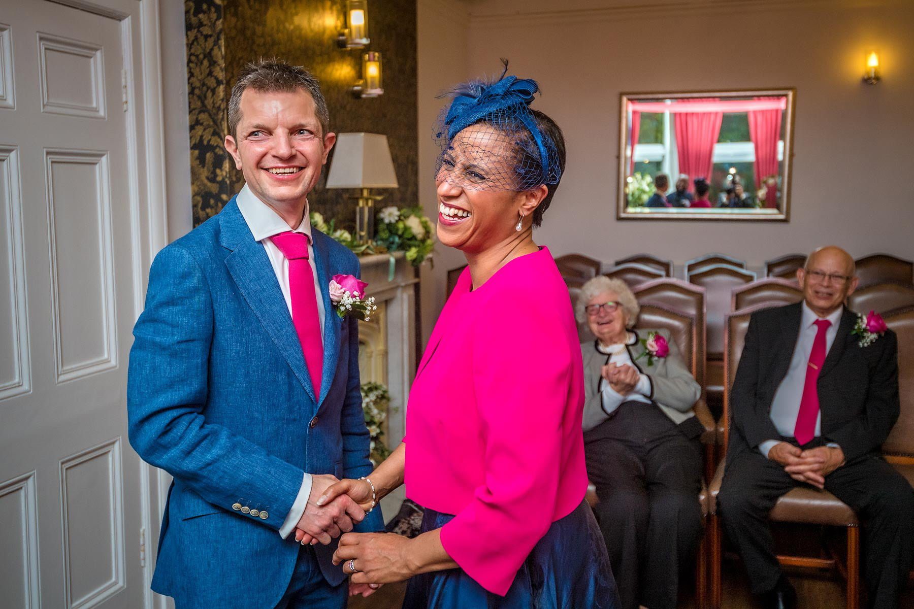 The bride and groom holding hands and laughing in the Garden Room in Southwark