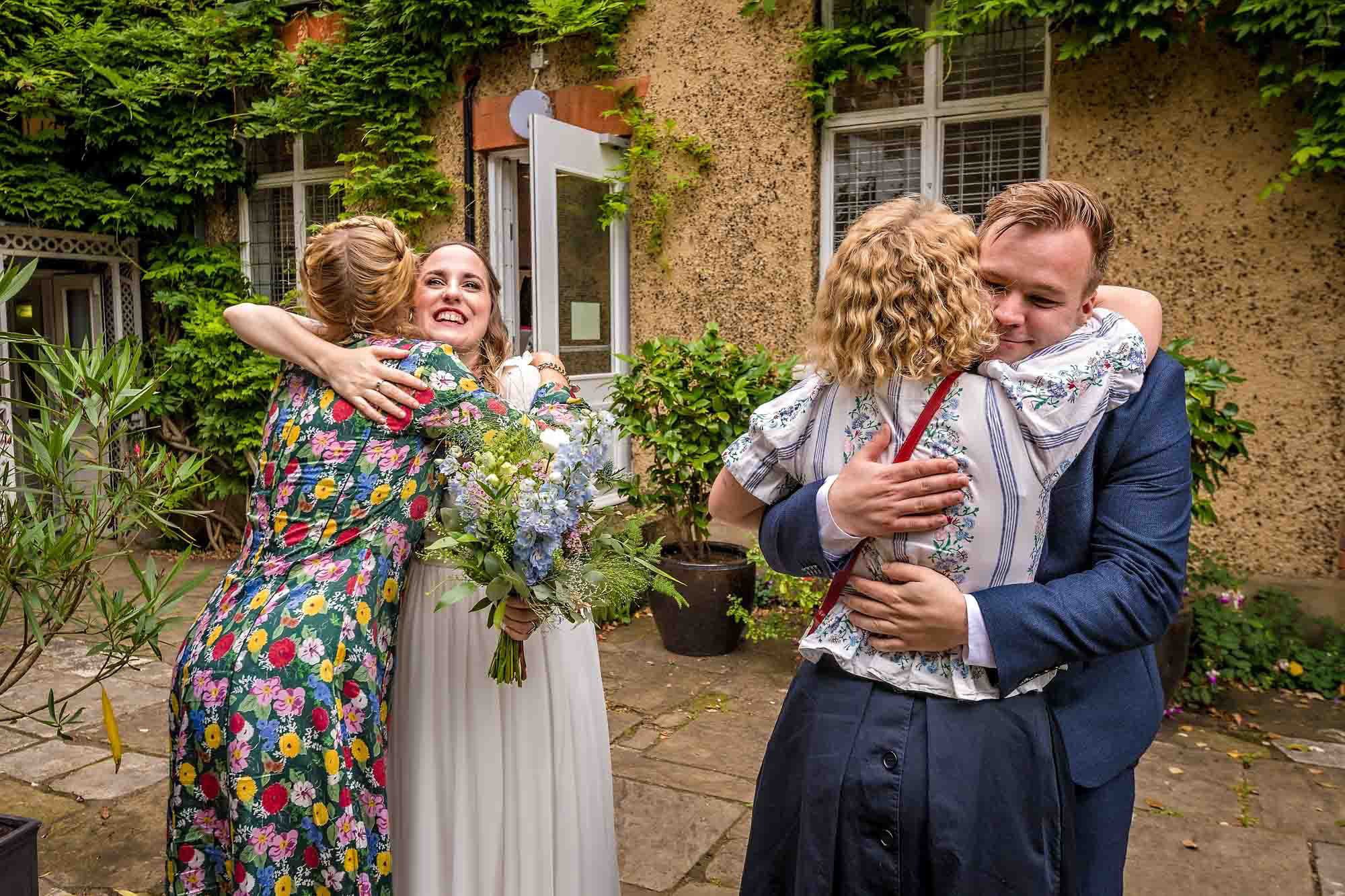 Friends and family hug the bride and groom to congratulate them on their marriage