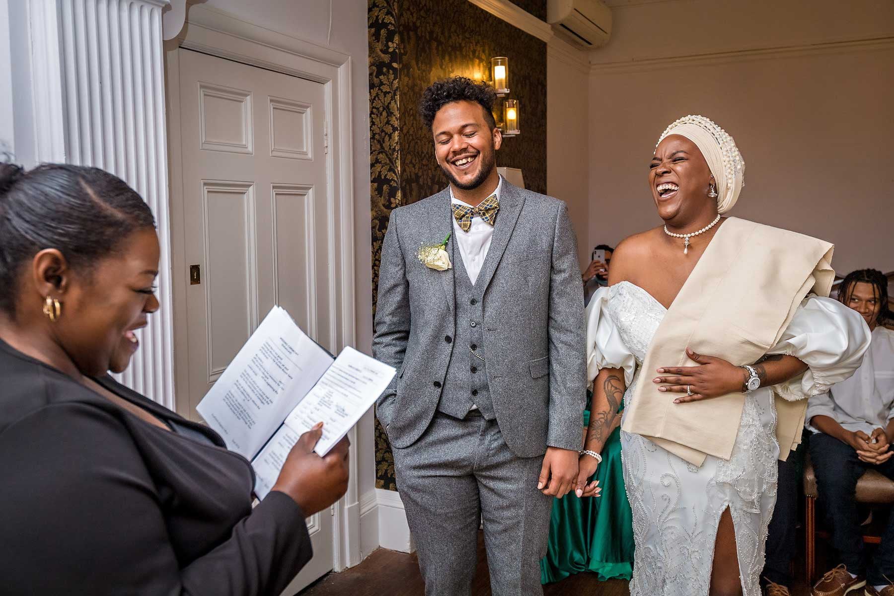 The bride and groom both laughing during their wedding ceremony in London