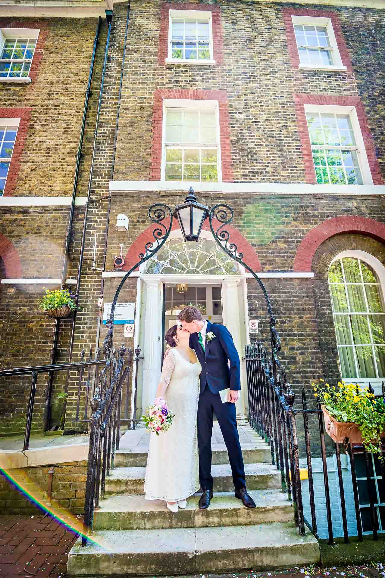 Newly married couple kissing on steps of Southwark Register Office