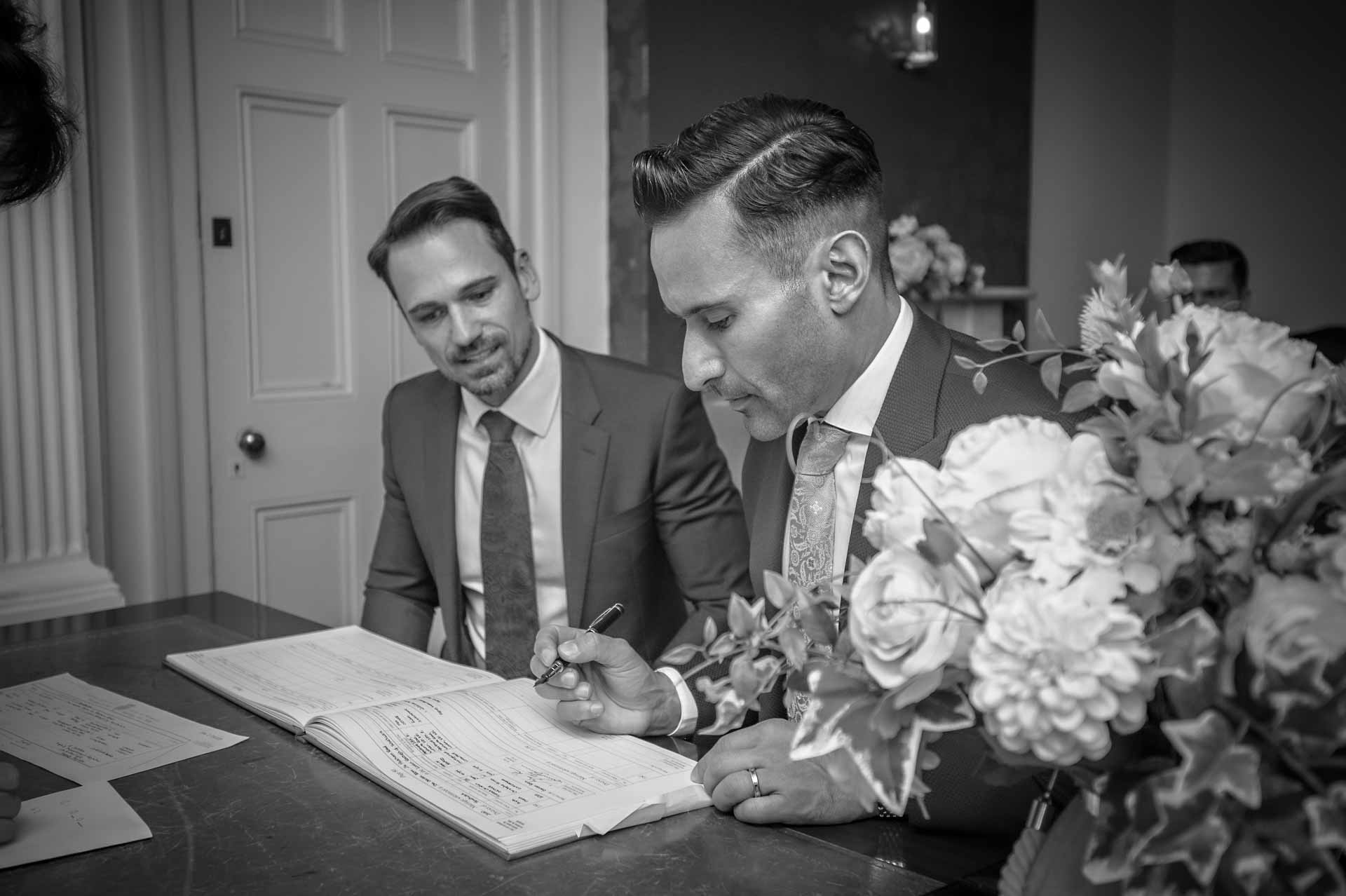 LGBTQ+ wedding couple signing the register at Southwark Town Hall