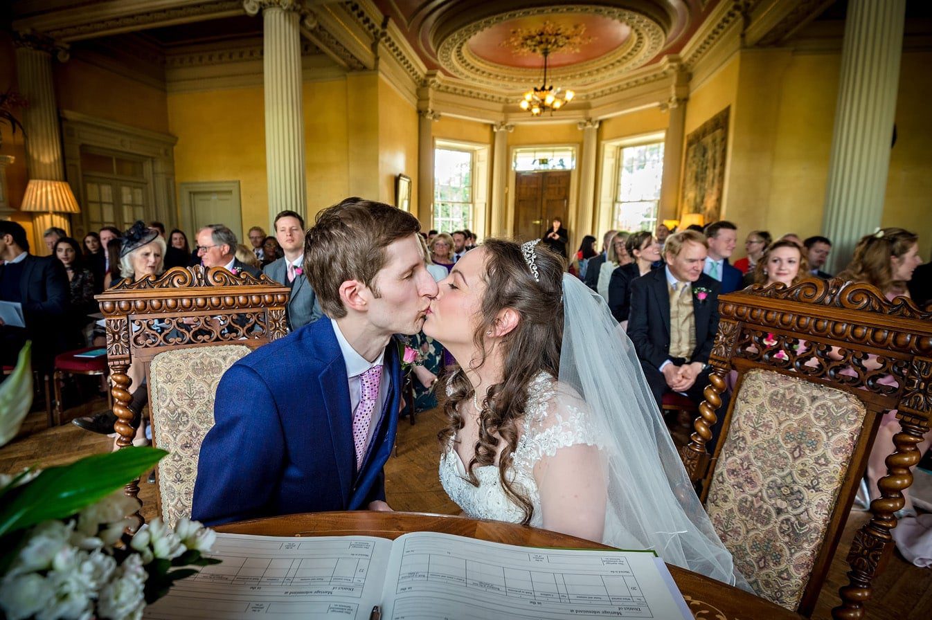 Bride and Groom kiss after the register signing at their Hampton Court House wedding.