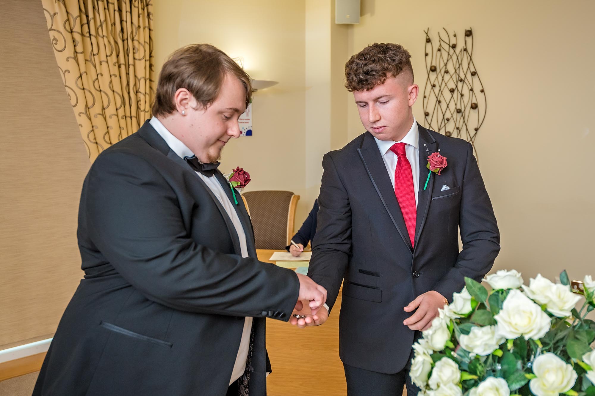 The best man presents the groom with his wedding ring in Penallta House