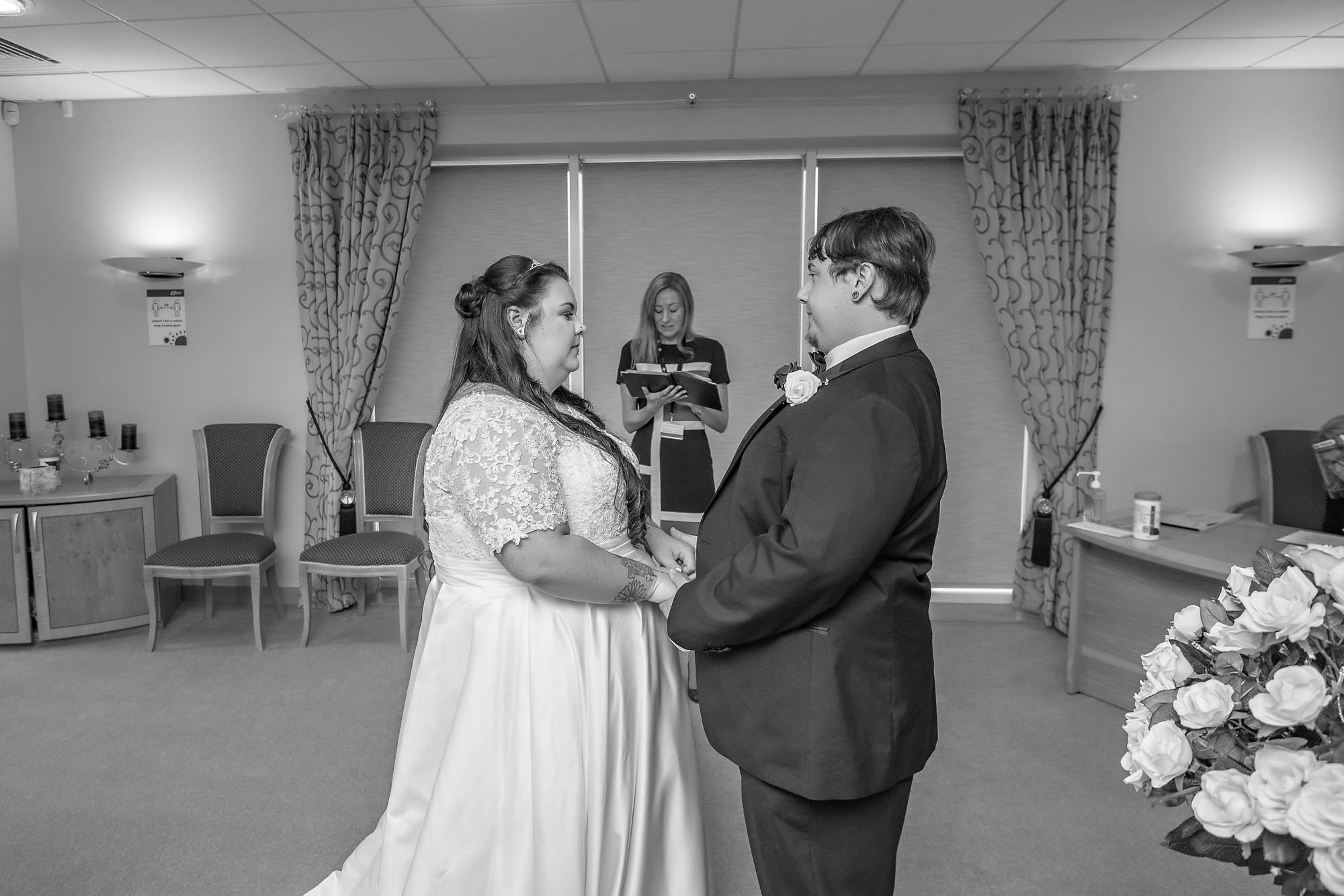 The bride and groom hold each others hands at their wedding ceremony in Caerphilly Register Office