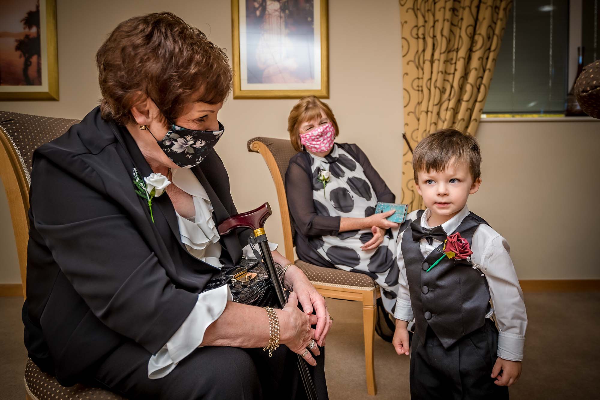 Wedding guests wearing COVID-19 face masks with little boy in waistcoast at Penallta House