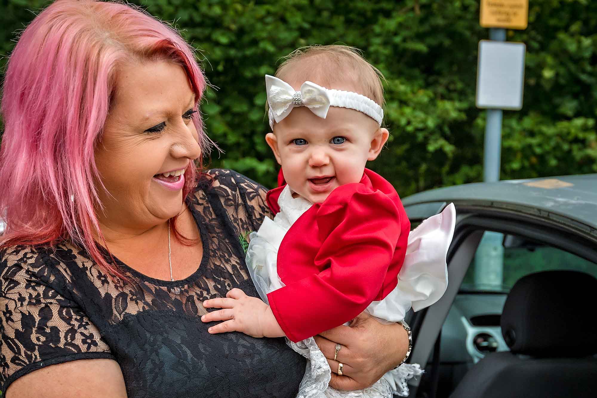 Baby in wedding dress being held by female relative at Penallta House