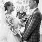 Bride and Groom holding Hands and Looking at each other in Ceremony