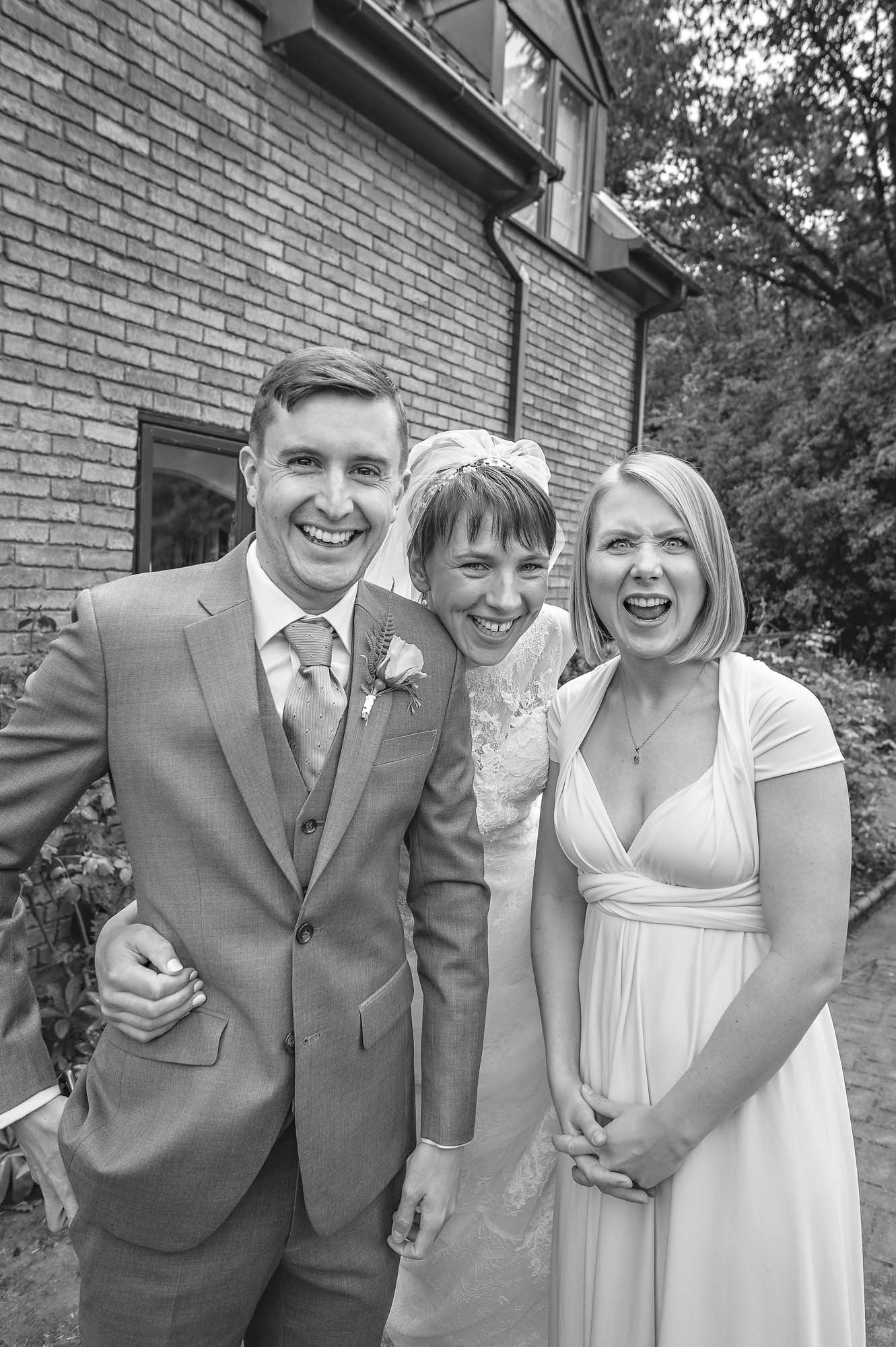 Bride with siblings laughing at pulling faces at wedding preparations