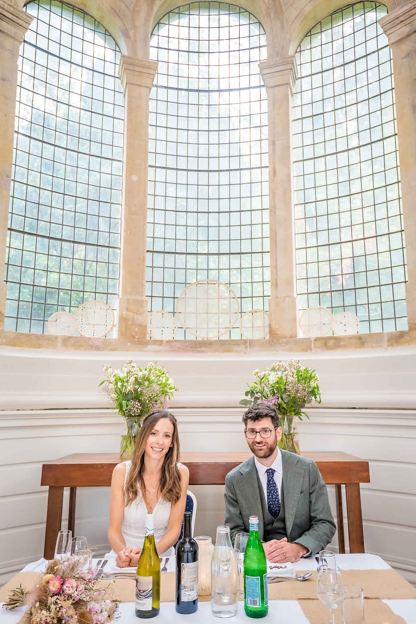 Bride and groom seated at table in the Anglican Chapel, Arnos Vale for their wedding breakfast