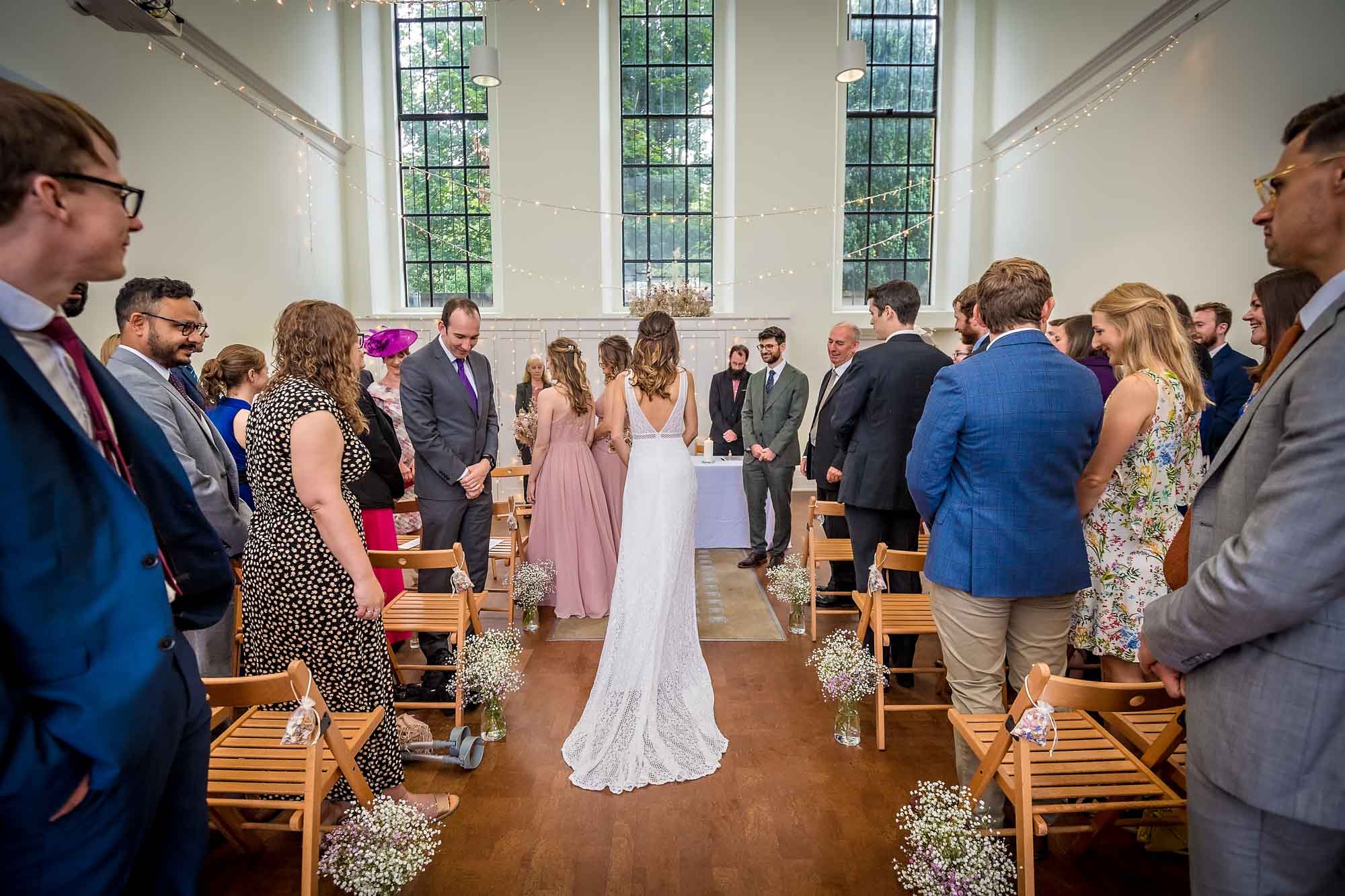 The bride walks down the aisle of the Spielman Centre at Arnos Vale