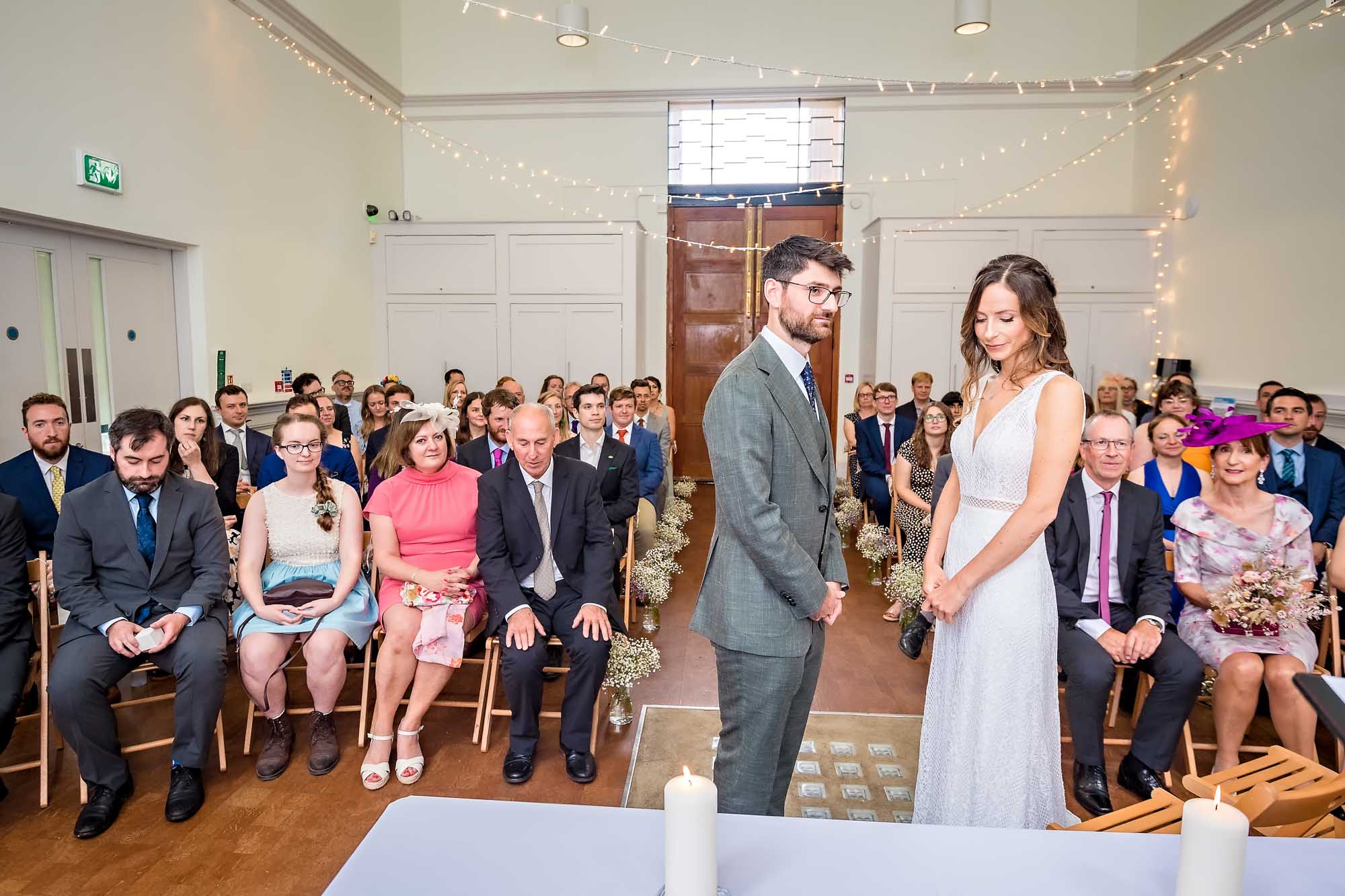 Pensive bride with groom at the 'altar' in the Spielman Centre, Arnos Vale