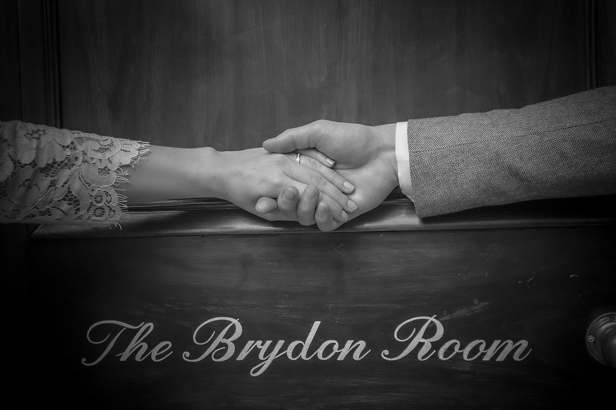 Bride and Groom's hands holding above Brydon Room door at Chelsea Old Town Hall