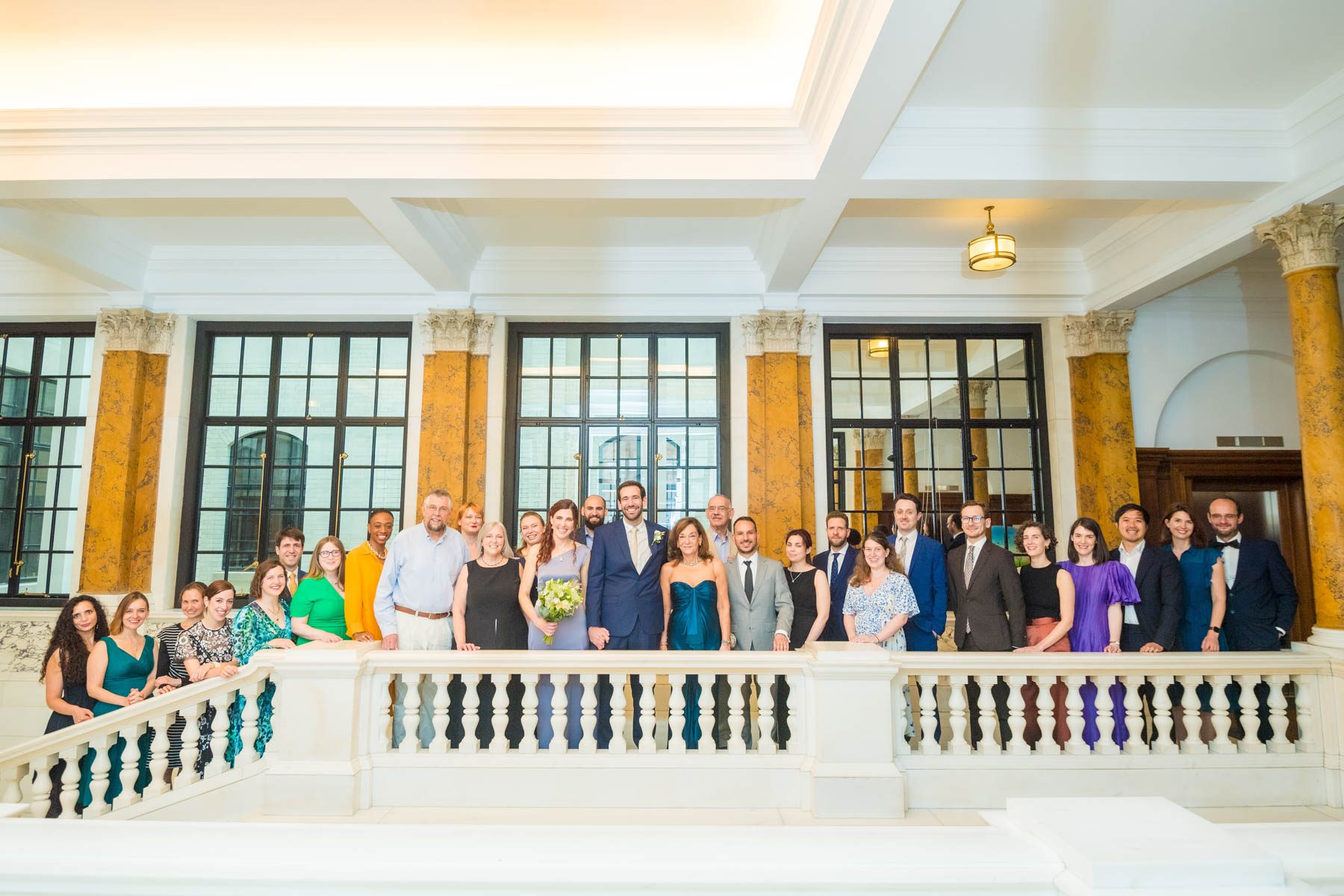 Wedding party lined up behind landing balustrade at Camden Town Hall