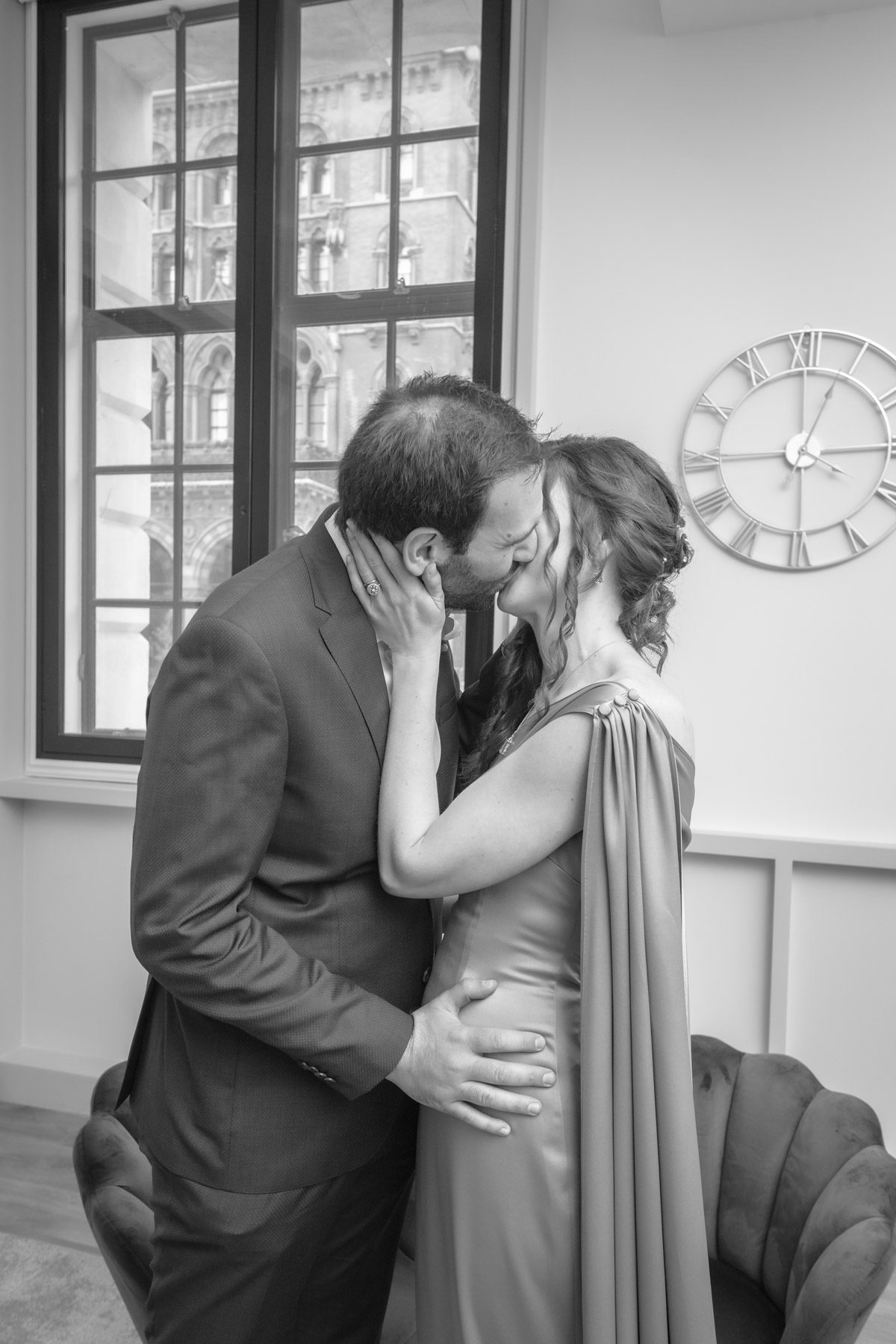 Black and white photo of the groom kisses the bride at their marriage in Camden Town Hall