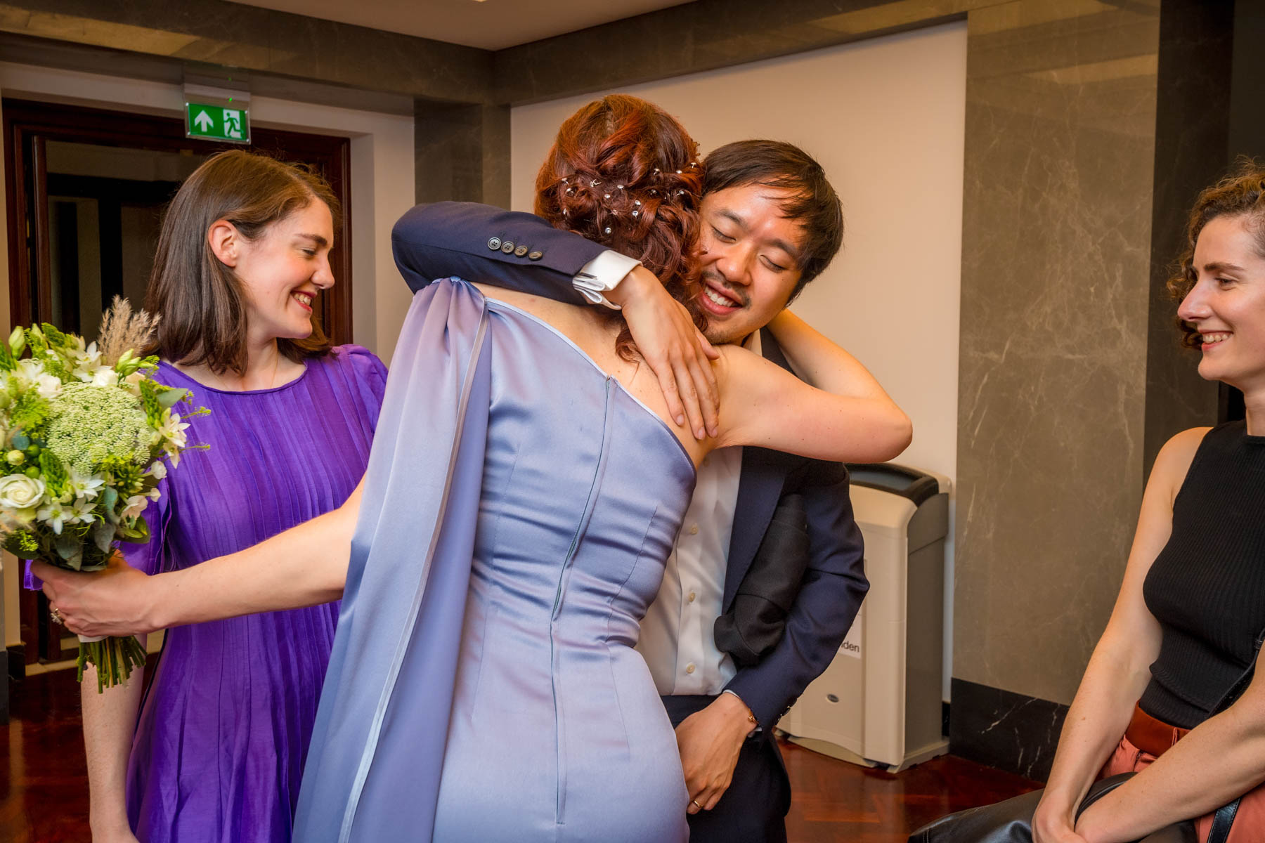 A guest hugs the bride in the waiting area at a Camden Town Hall wedding