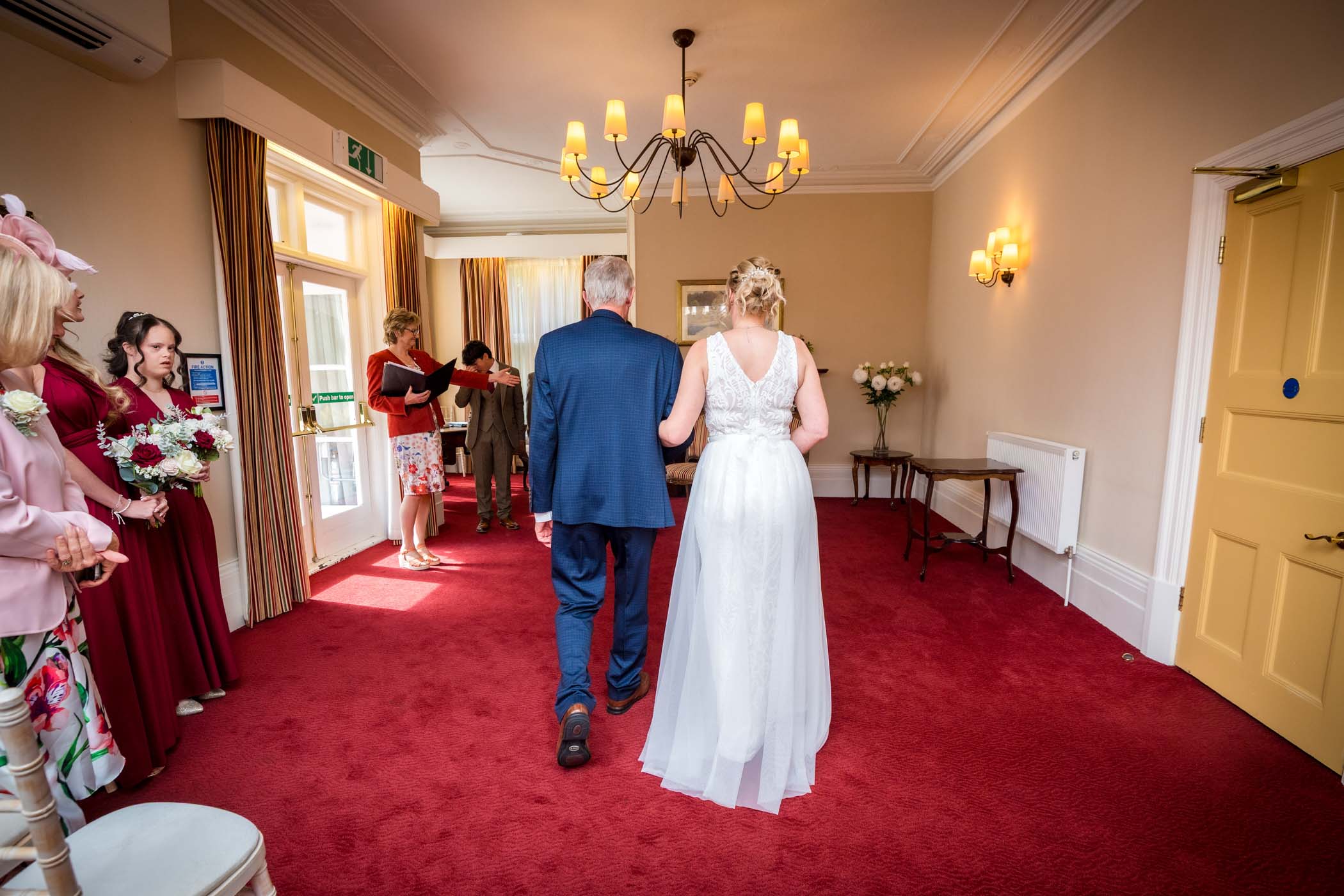 Photo from the back of bride walking down aisle with her father