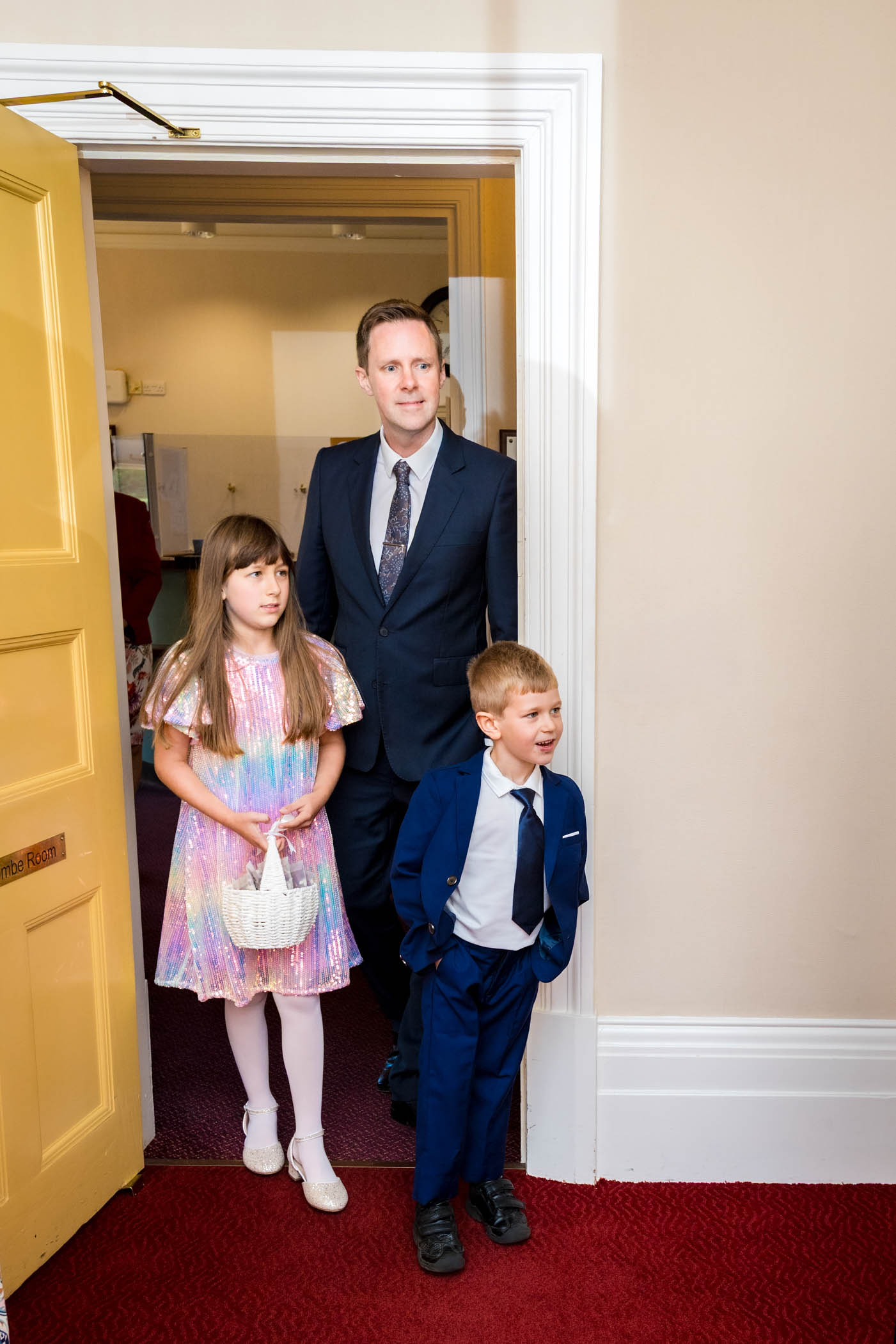 Man and two children walking through door into wedding room