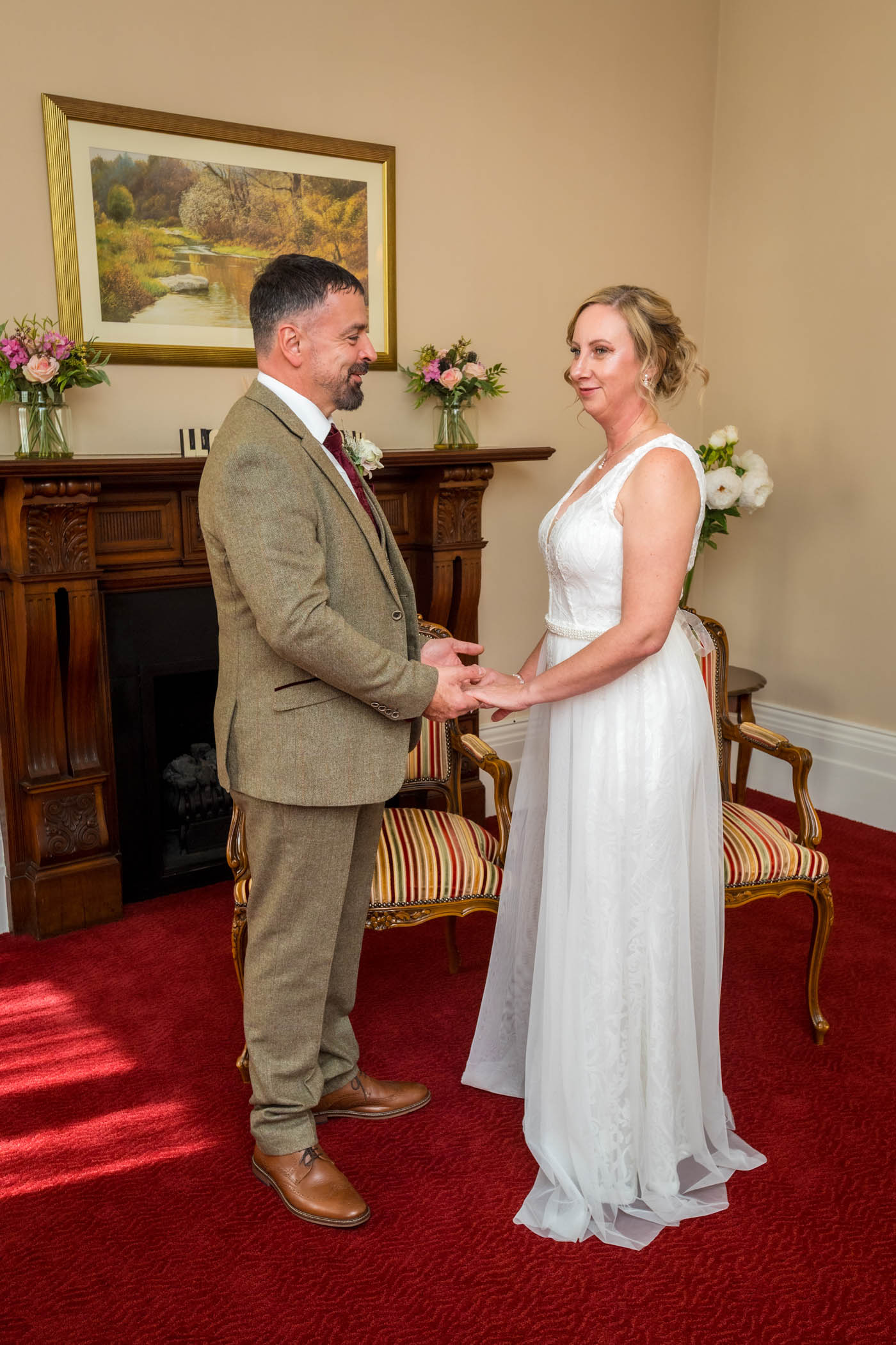 Bride and groom holding hands in the Liscombe Room in Newport
