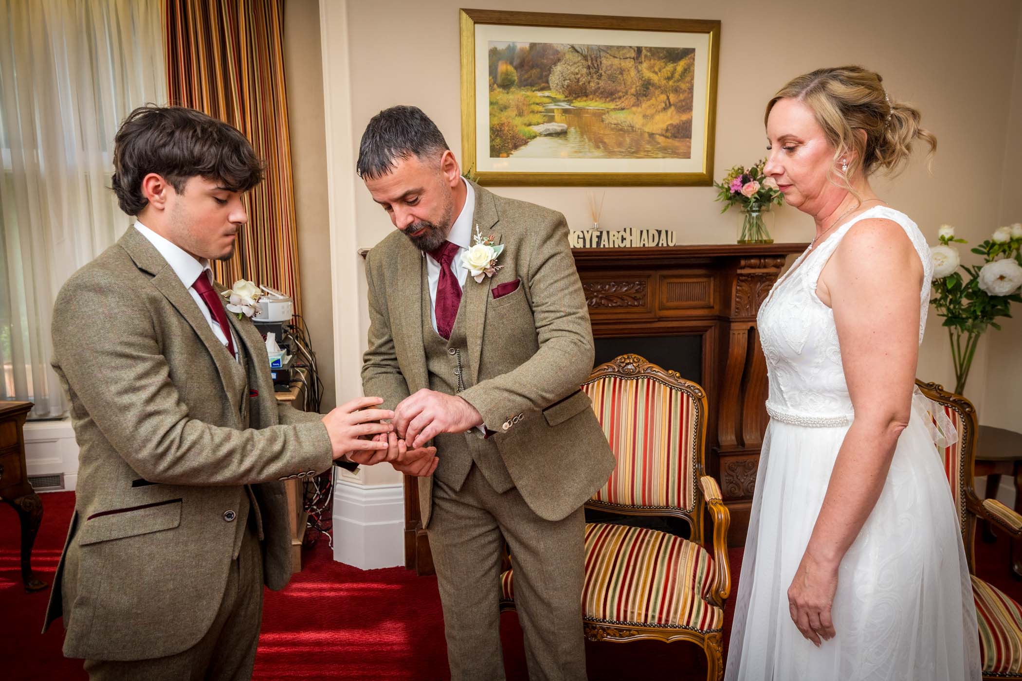 Groom's son presents ring and groom takes it whilst bride watches
