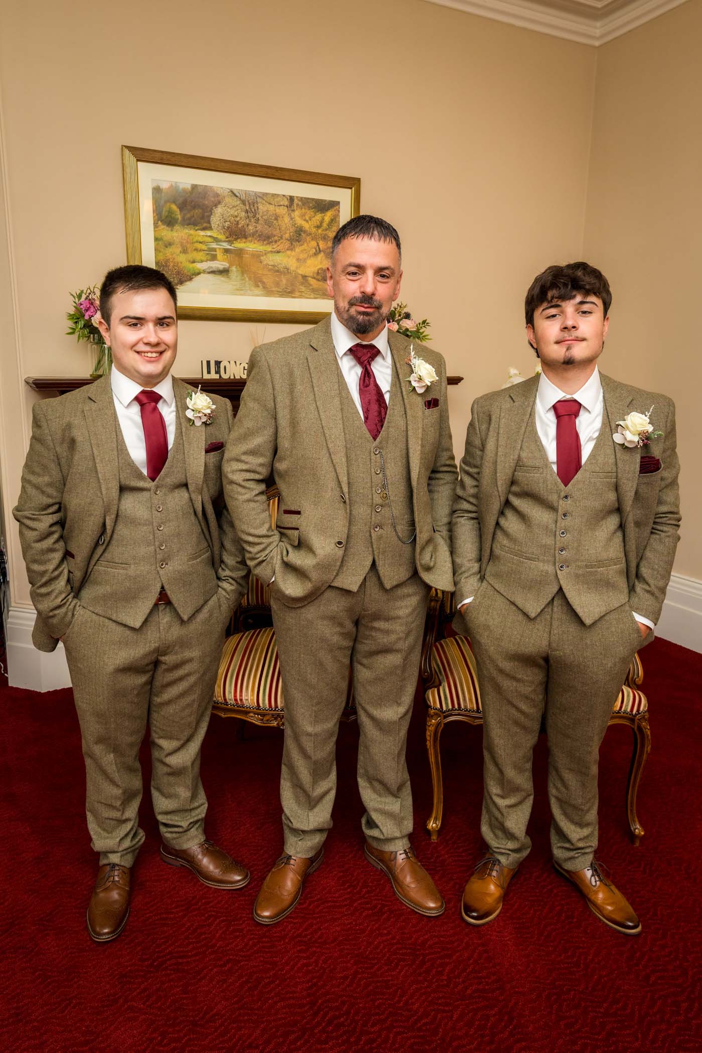 Three men in tweed suits posing infront of fireplace at Newport Mansion House