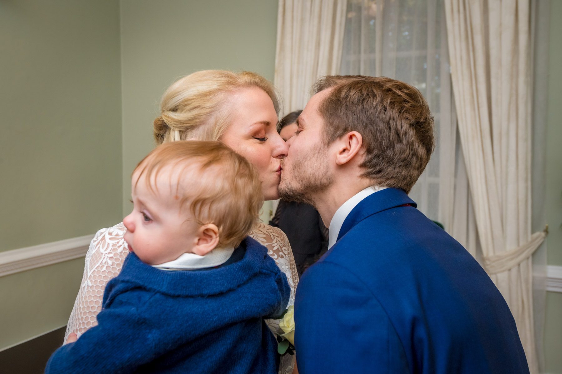 The couple kiss whilst carrying their baby at York House wedding in London.