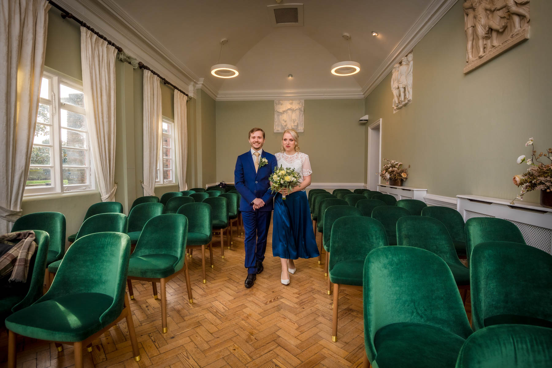 Couple walking down the aisle in the empty Loggia Room at York House, Richmond.