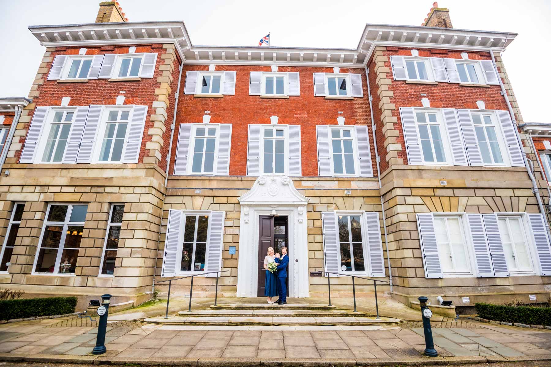 Newlyweds pose with their baby son outside York House in Twickenham.