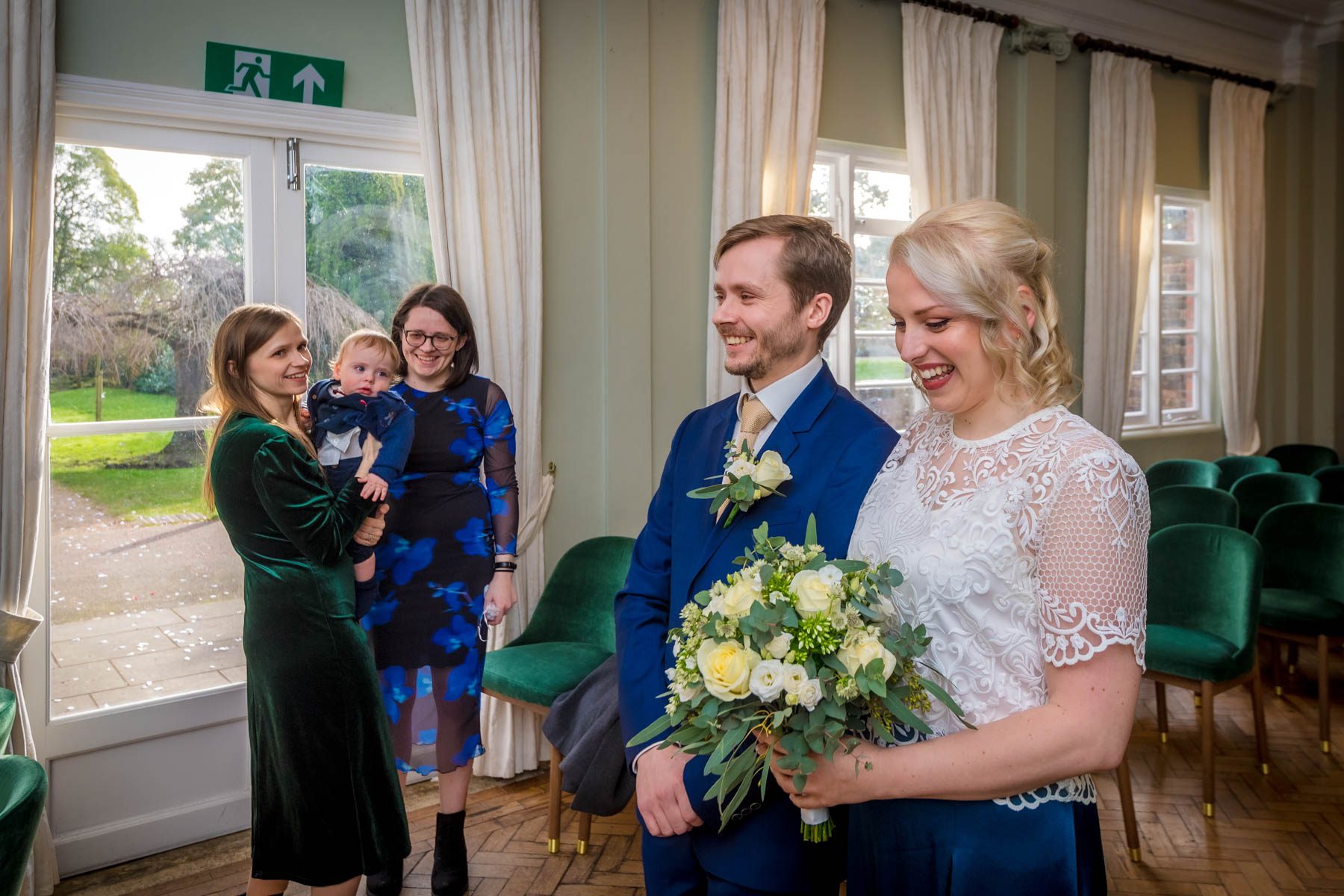 Couple walking together down aisle with smiling guests watching at York House in London.