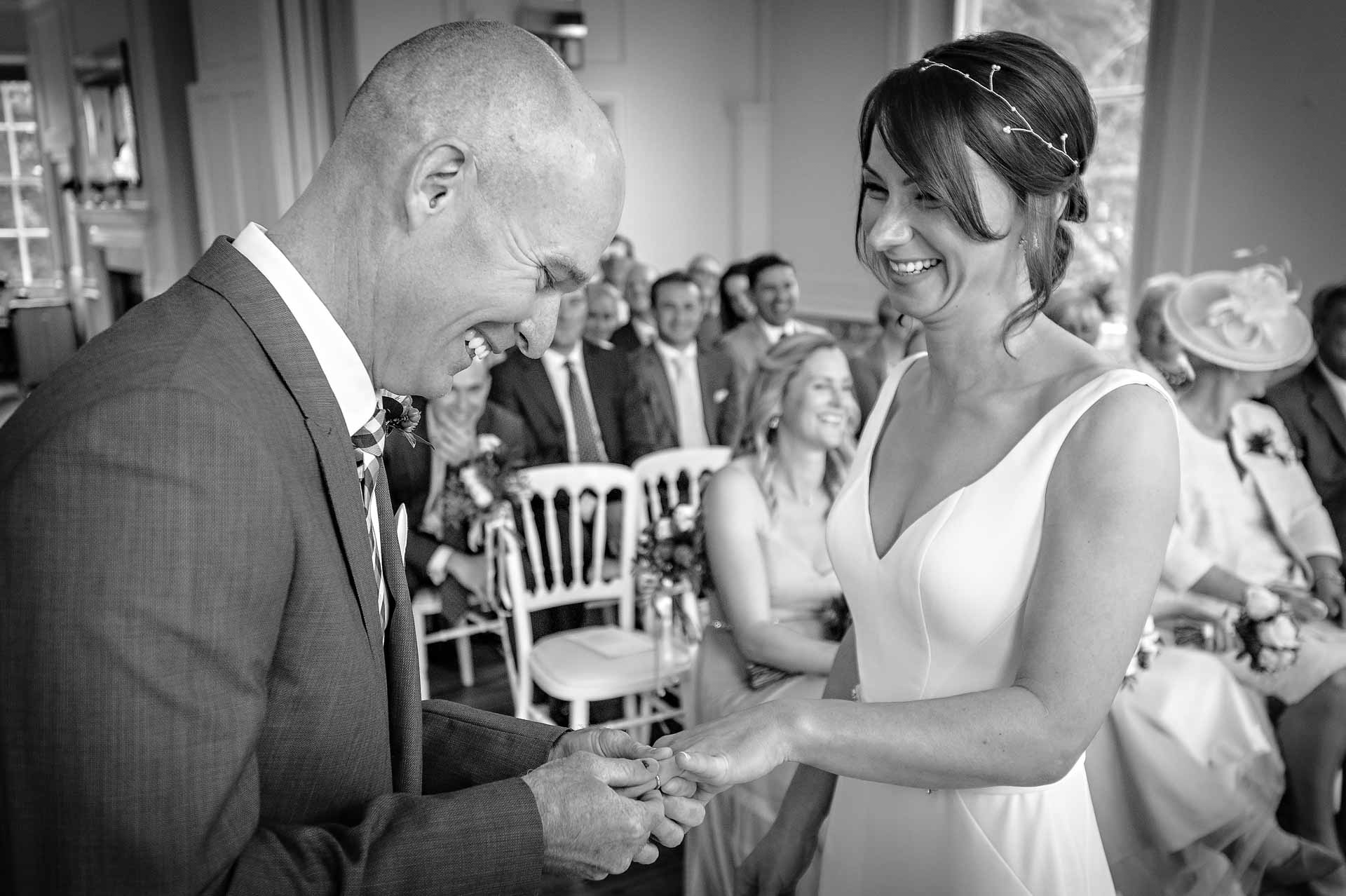 Happy Photo of Groom Placing Ring on Bride's Finger