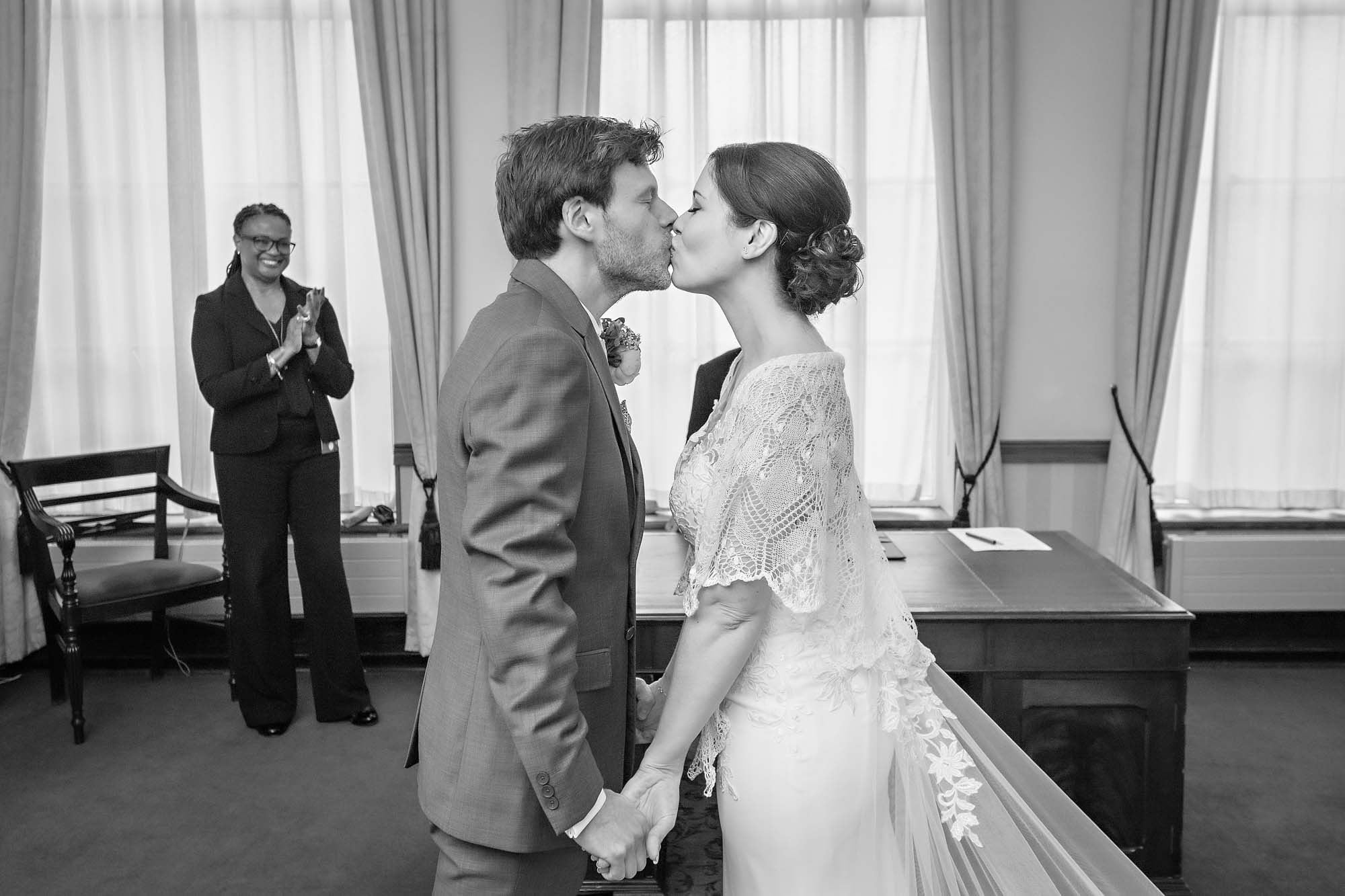 The couple share there first kiss as a registrar claps in the background