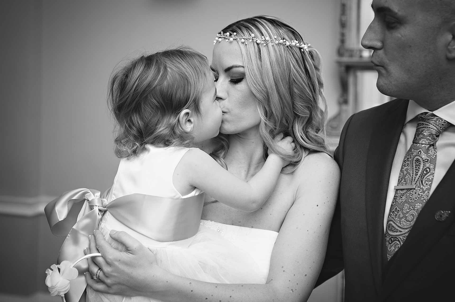 Bridesmaid Toddler Kisses Bride at wedding in Asia House