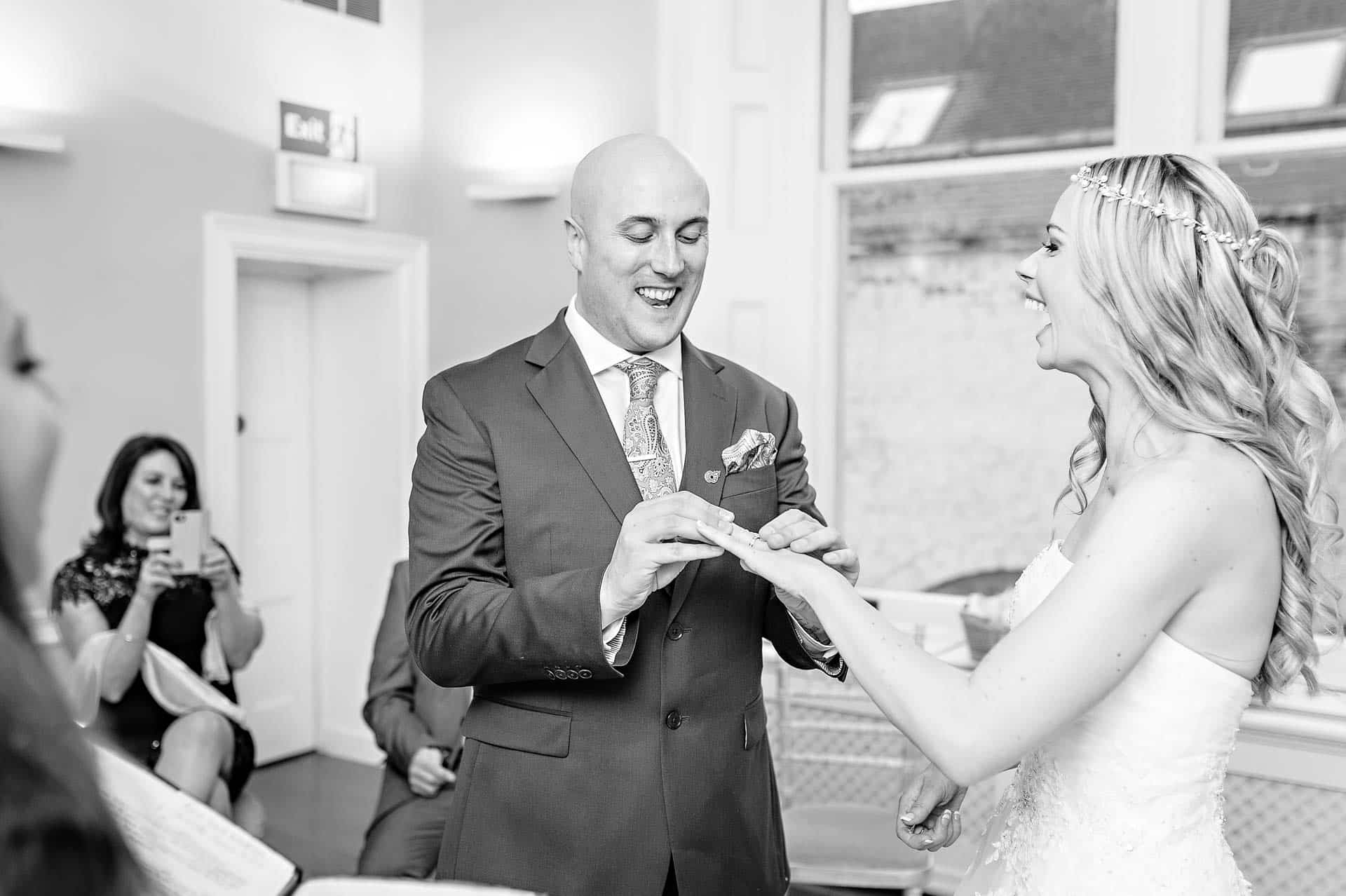 Bride and Groom Laughing as They Exchange Rings