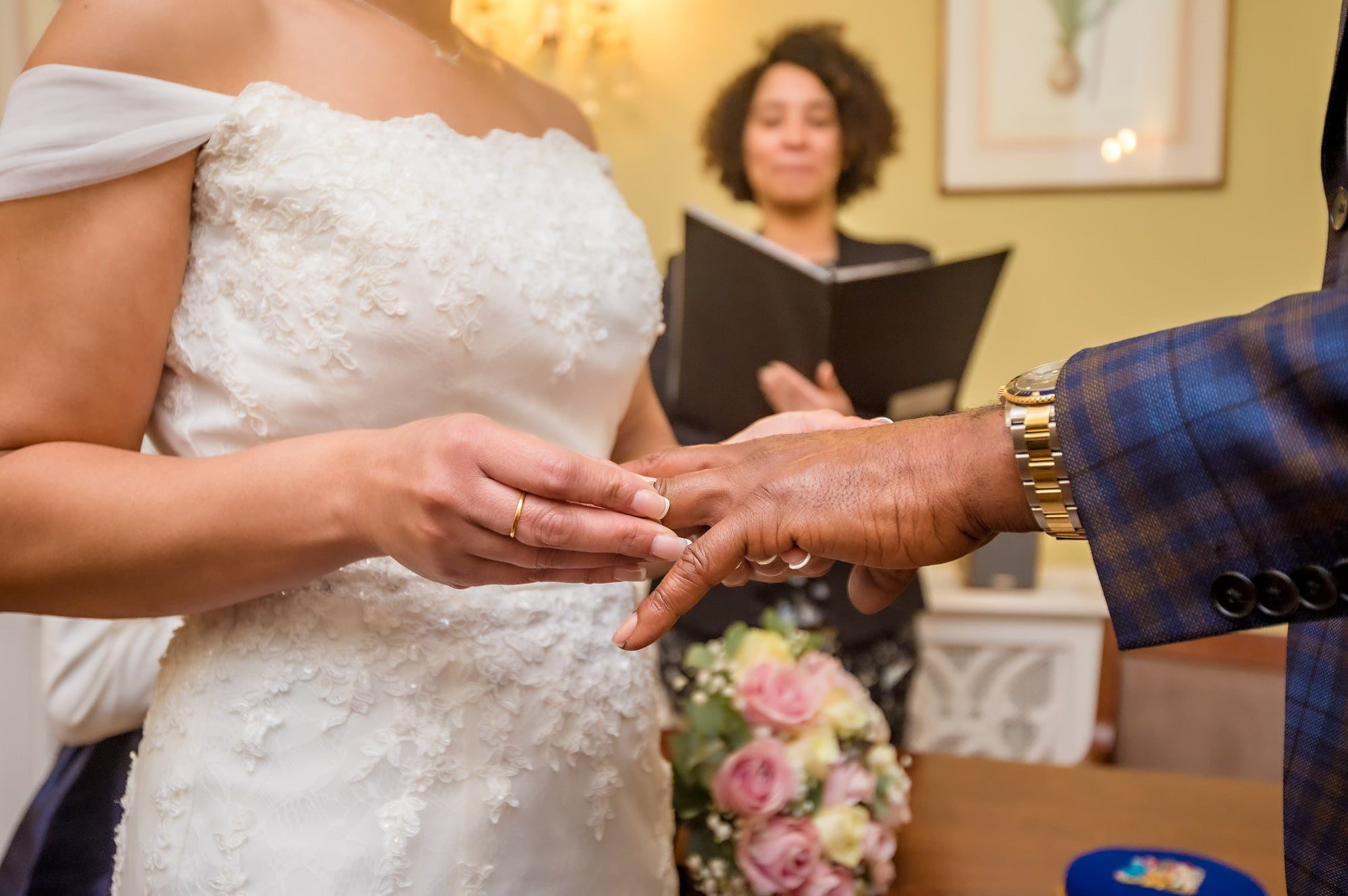 Close-up of the bride placing the ring on her groom's finger in Chelsea