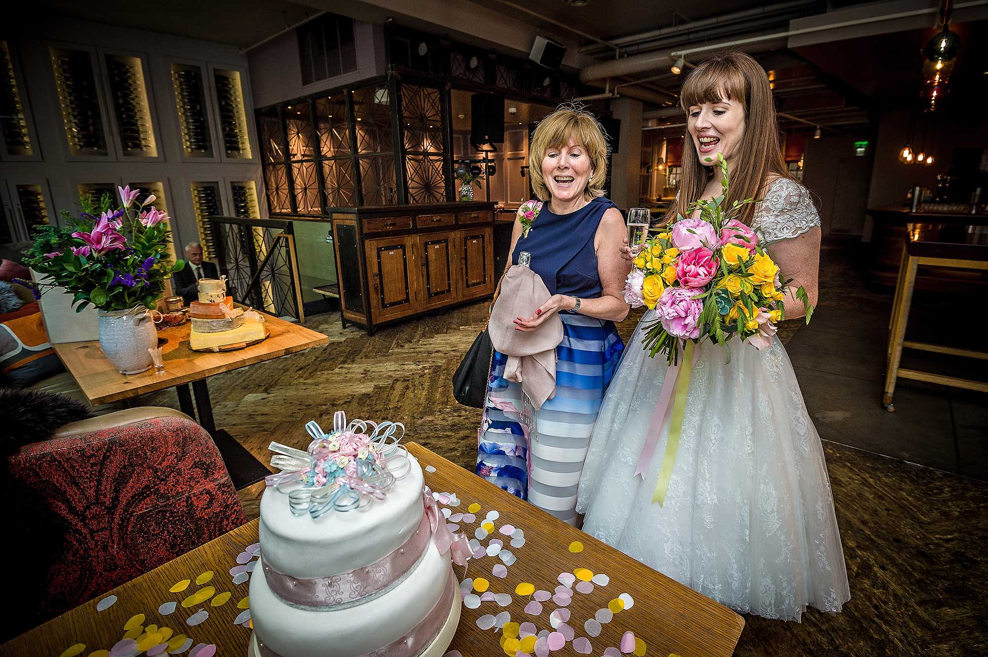 Bride with mum admiring wedding cake at reception