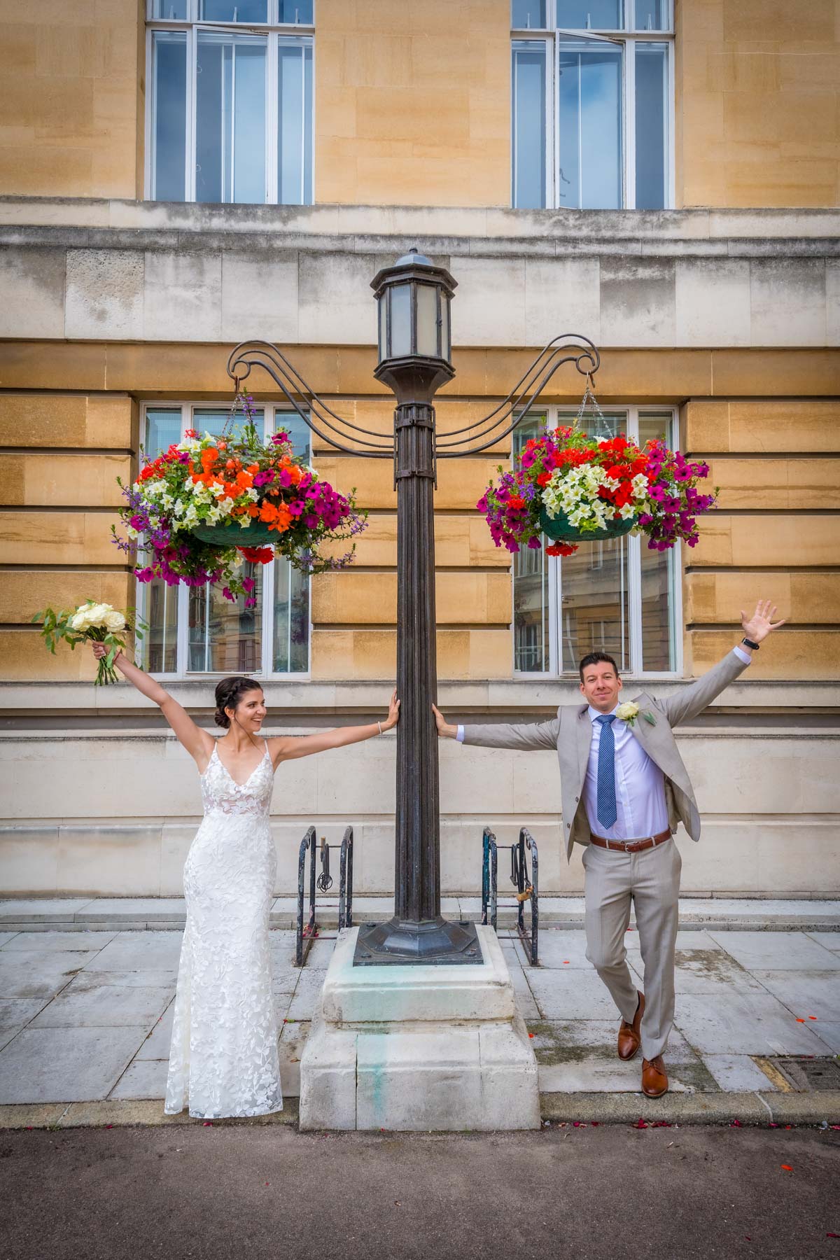 Natural portrait of couple under floral hanging baskets at Wandsworth Town Hall