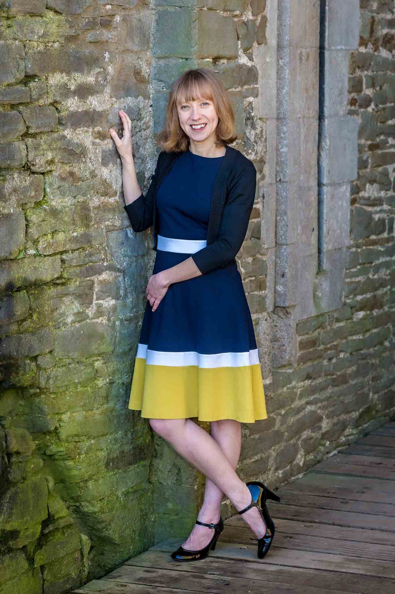 Lady posing against wall at Caerphilly Castle for dating profile