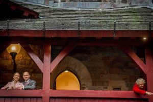 Couple posing at Castell Coch with stranger lady pointing