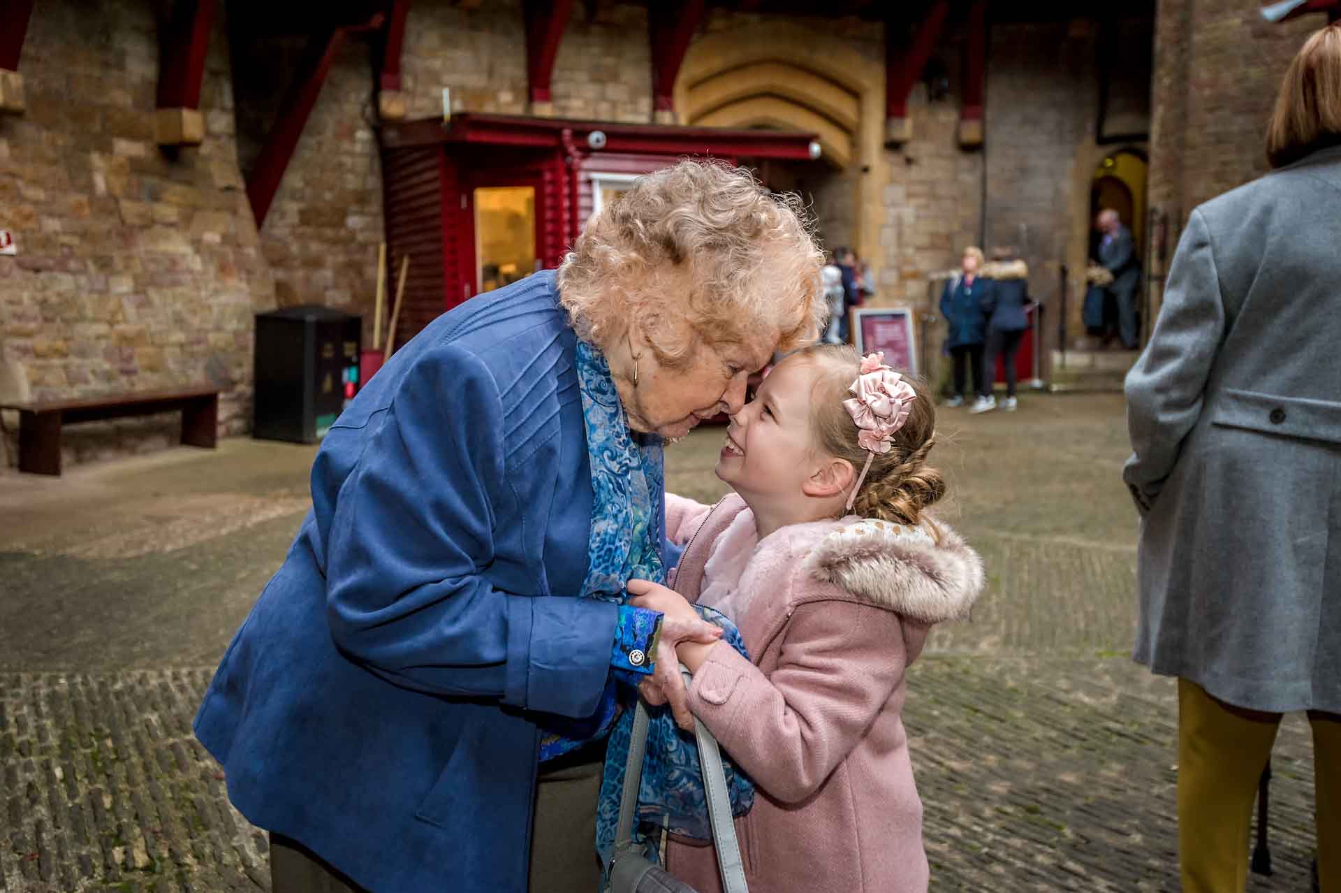 Grandma and granddaughter holding each other in courtyard at Castell Coch