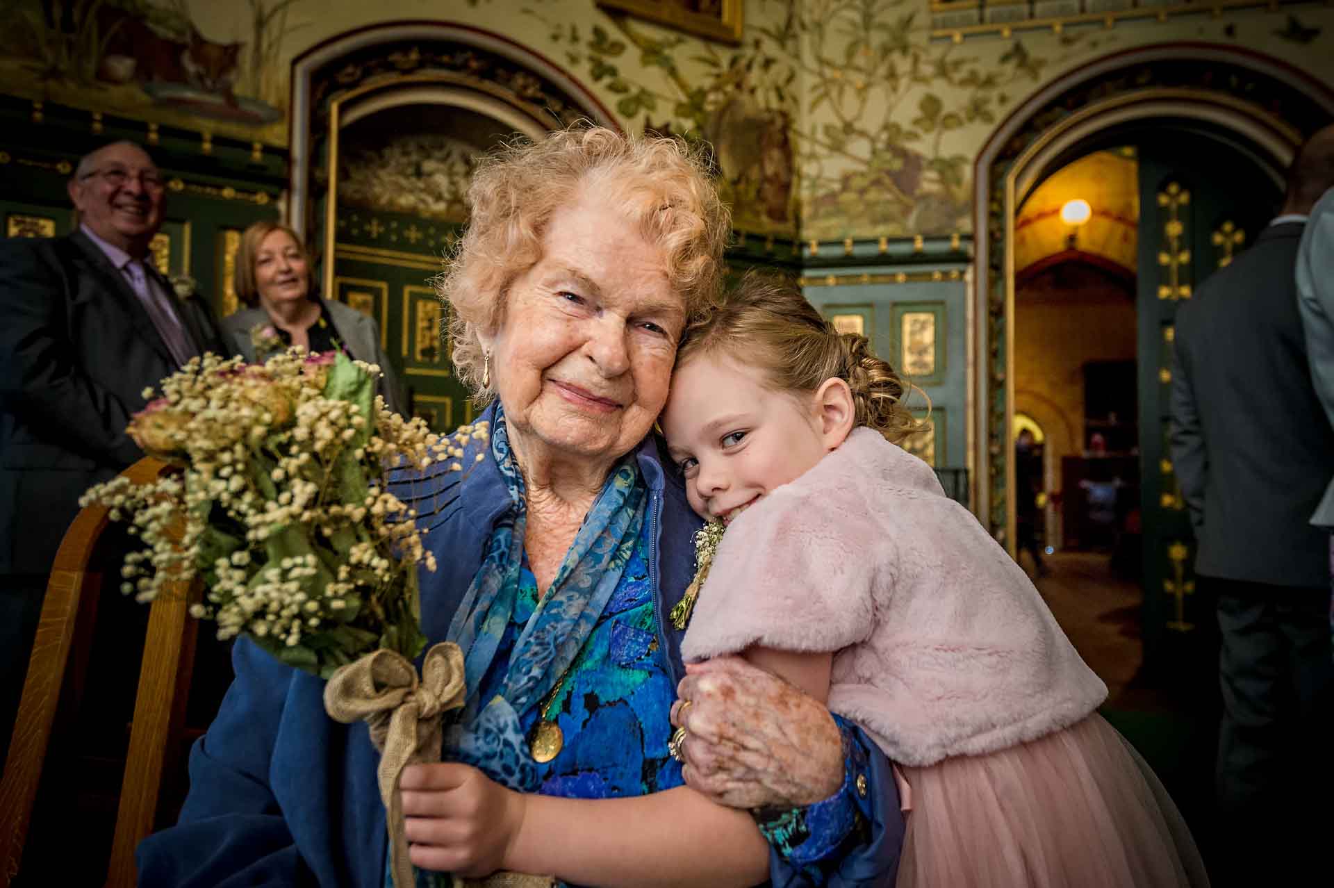 Grandmother with granddaughter cuddling at Castell Coch wedding