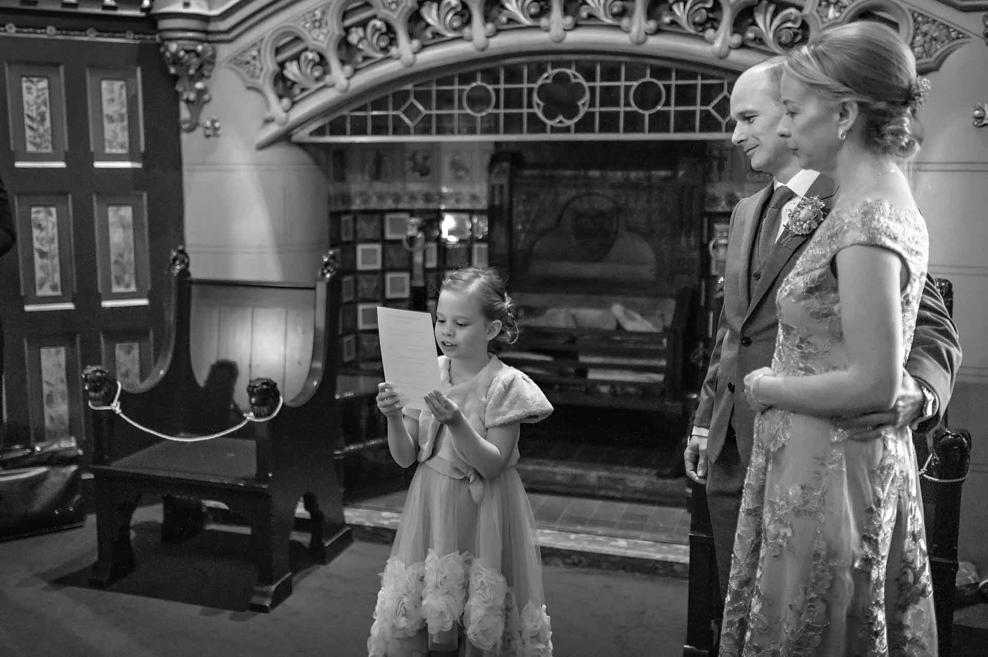 Little girl does a wedding reading at Castell Coch with parents watching