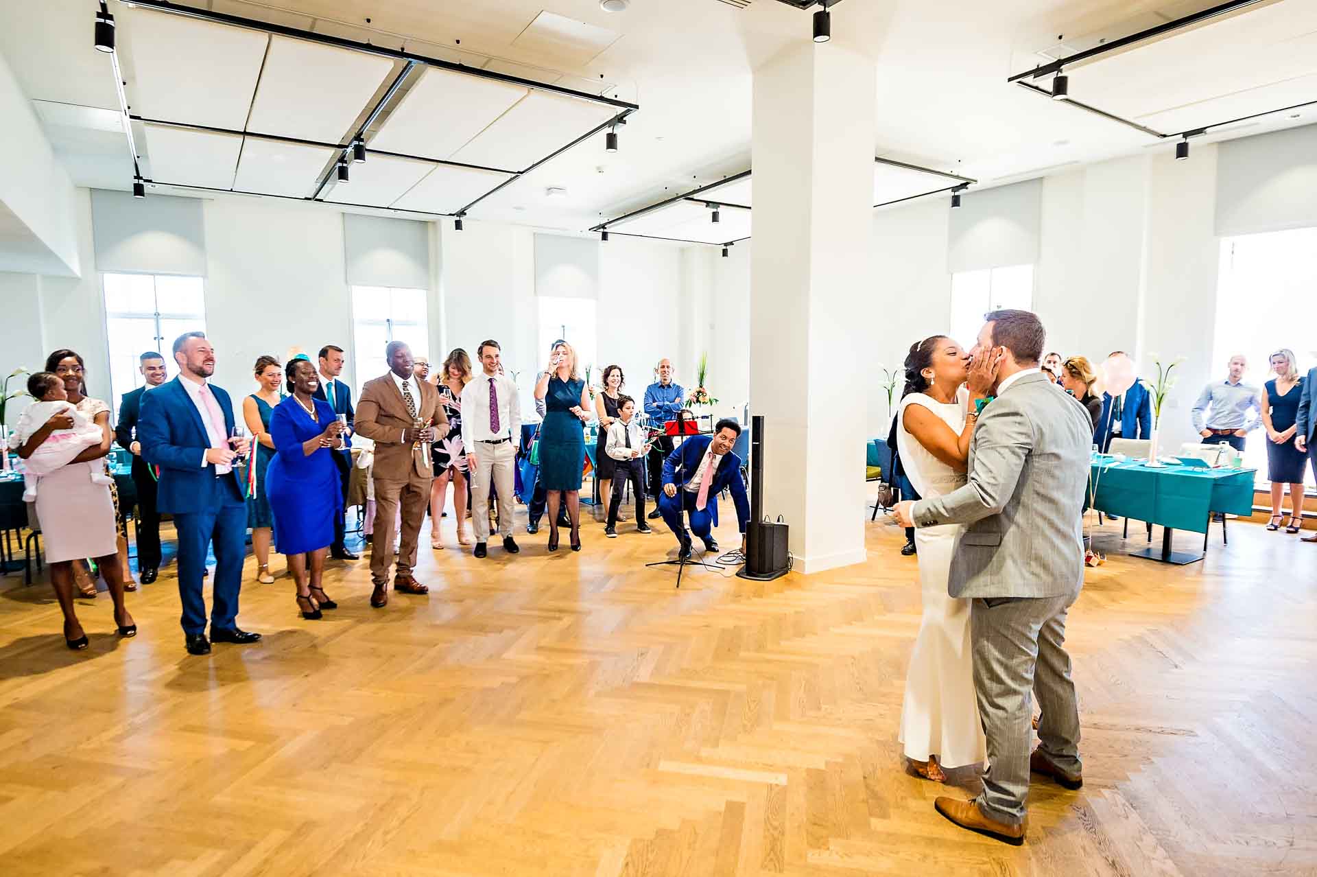 Wedding Couple Kissing as Guests Look On