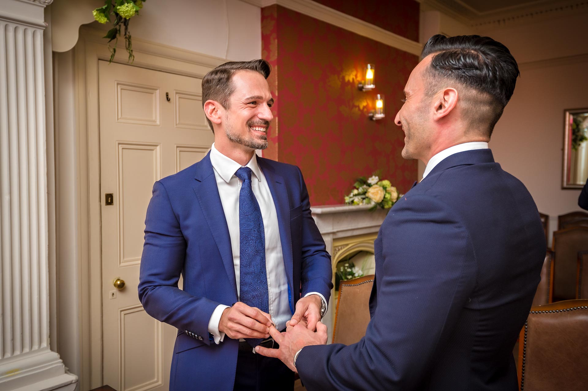 The grooms smiling at exchange of rings during their Southwark wedding, London