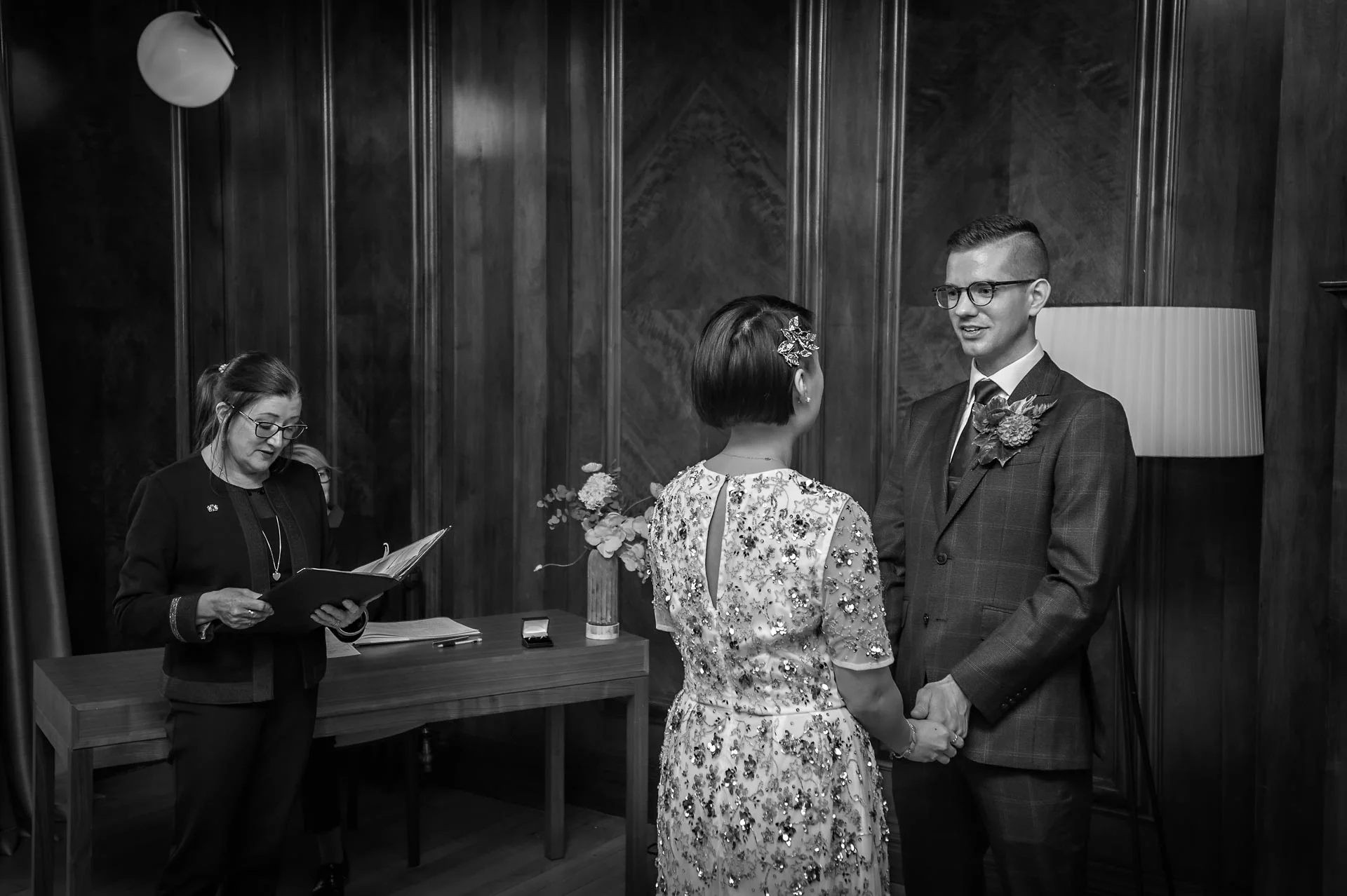 de bruid en bruidegom die naar elkaar Kijken met registrar leading op Old Marylebone Town Hall wedding in London