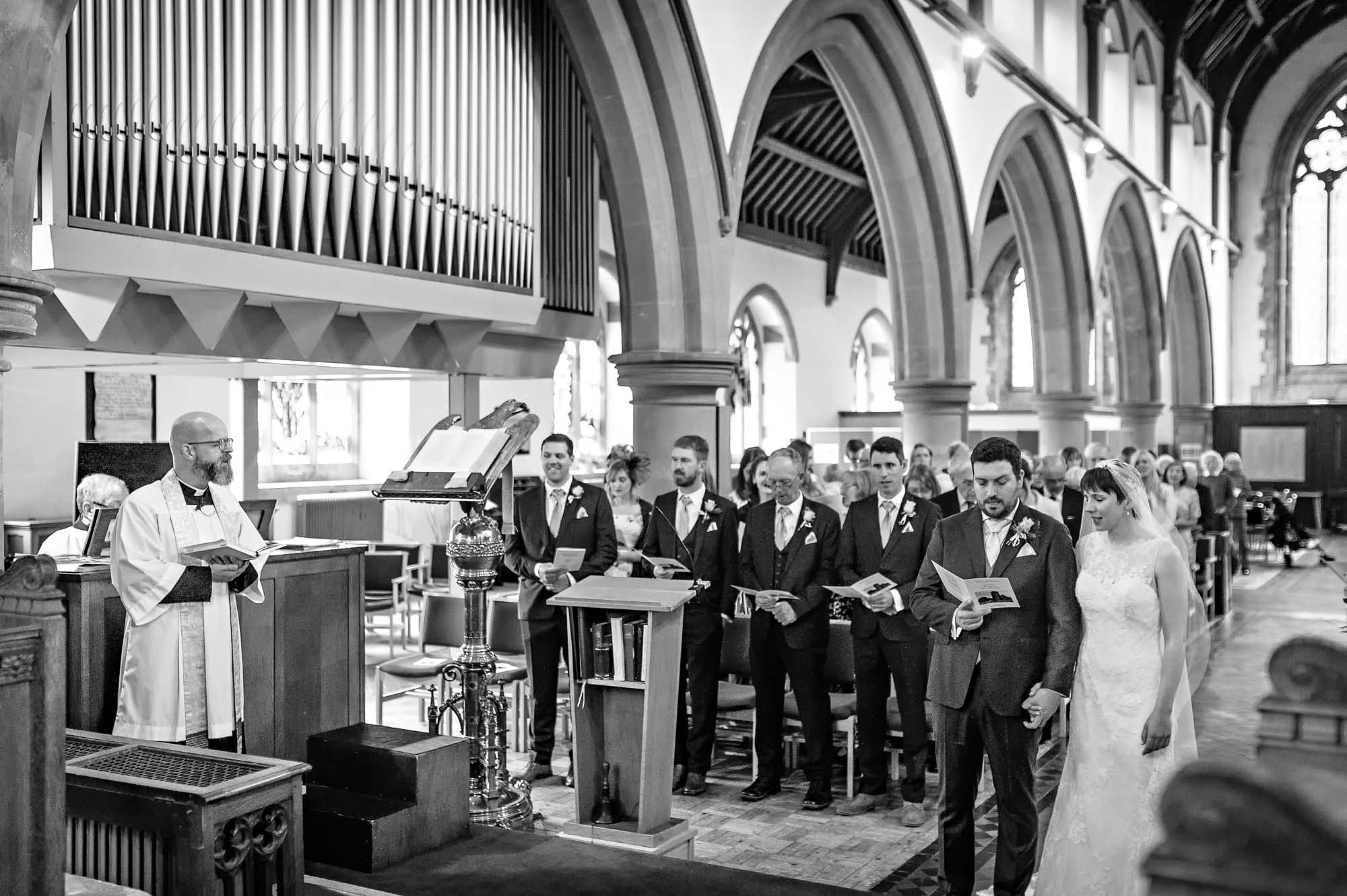 Overview of church wedding in Caerphilly - couple and congregation singing