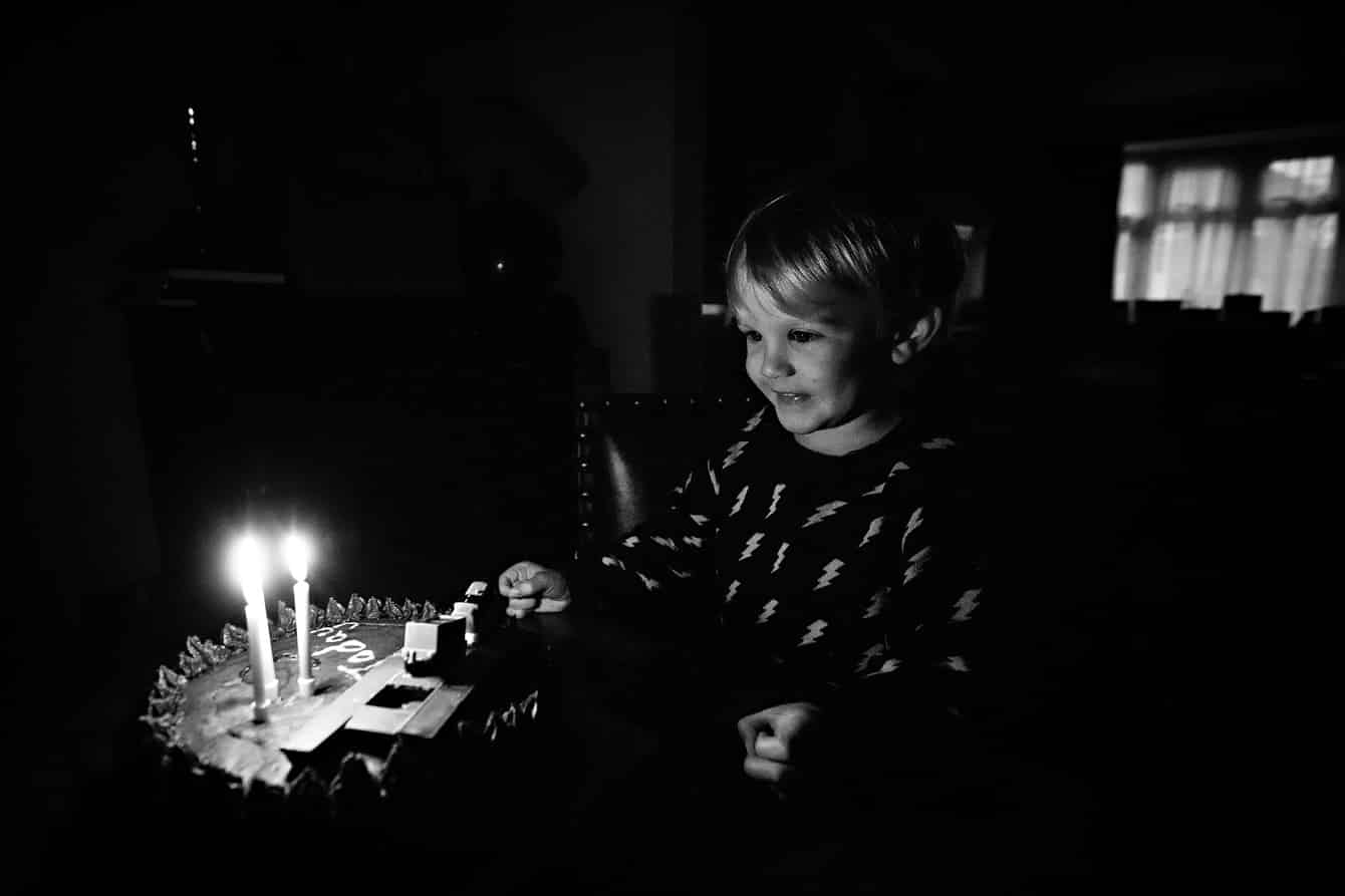 Little boy happy with candles on birthday cake