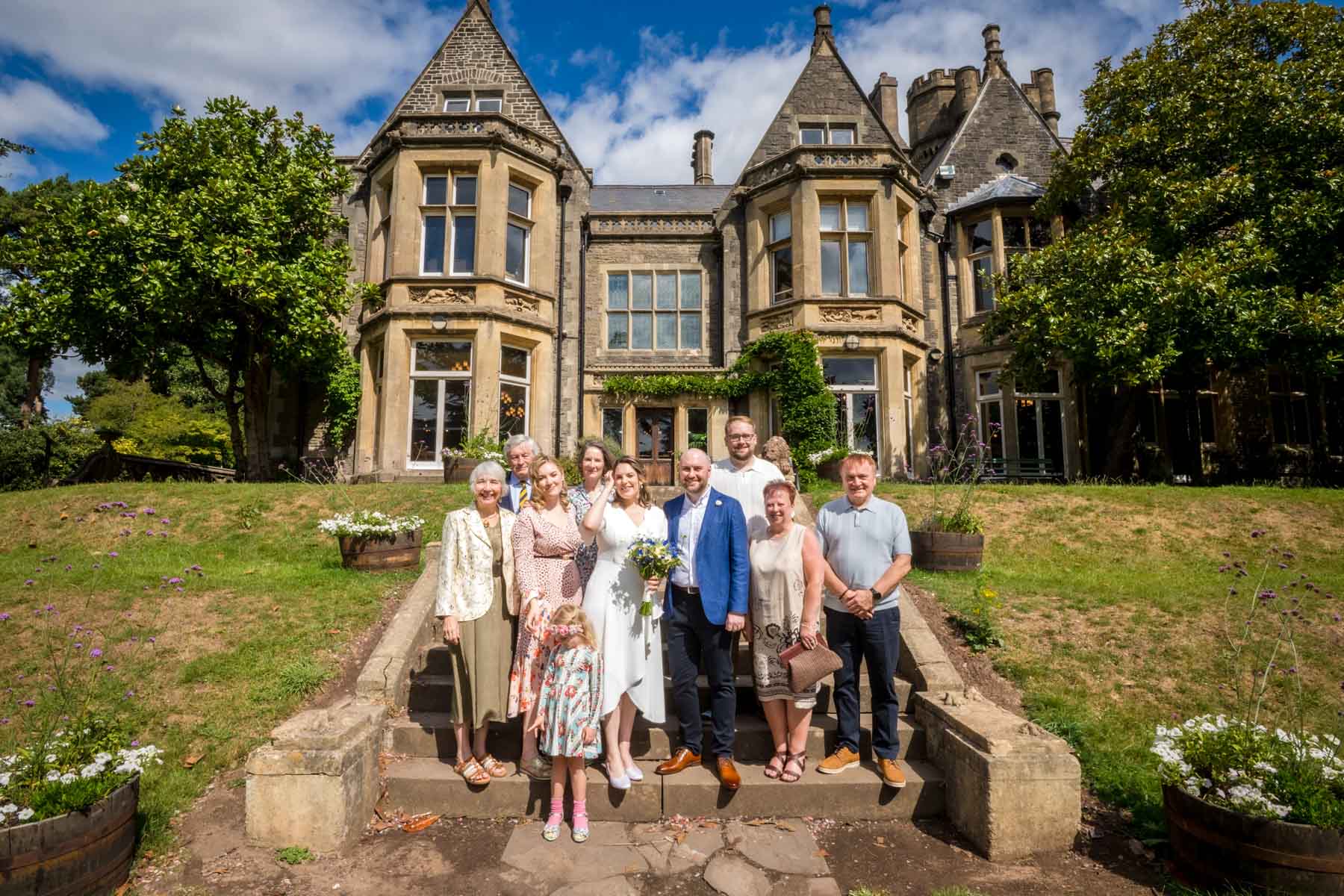 Gay Wedding Couple Walking Down Long Corridor The small wedding party pose in the steps in the gardens of Insole Court