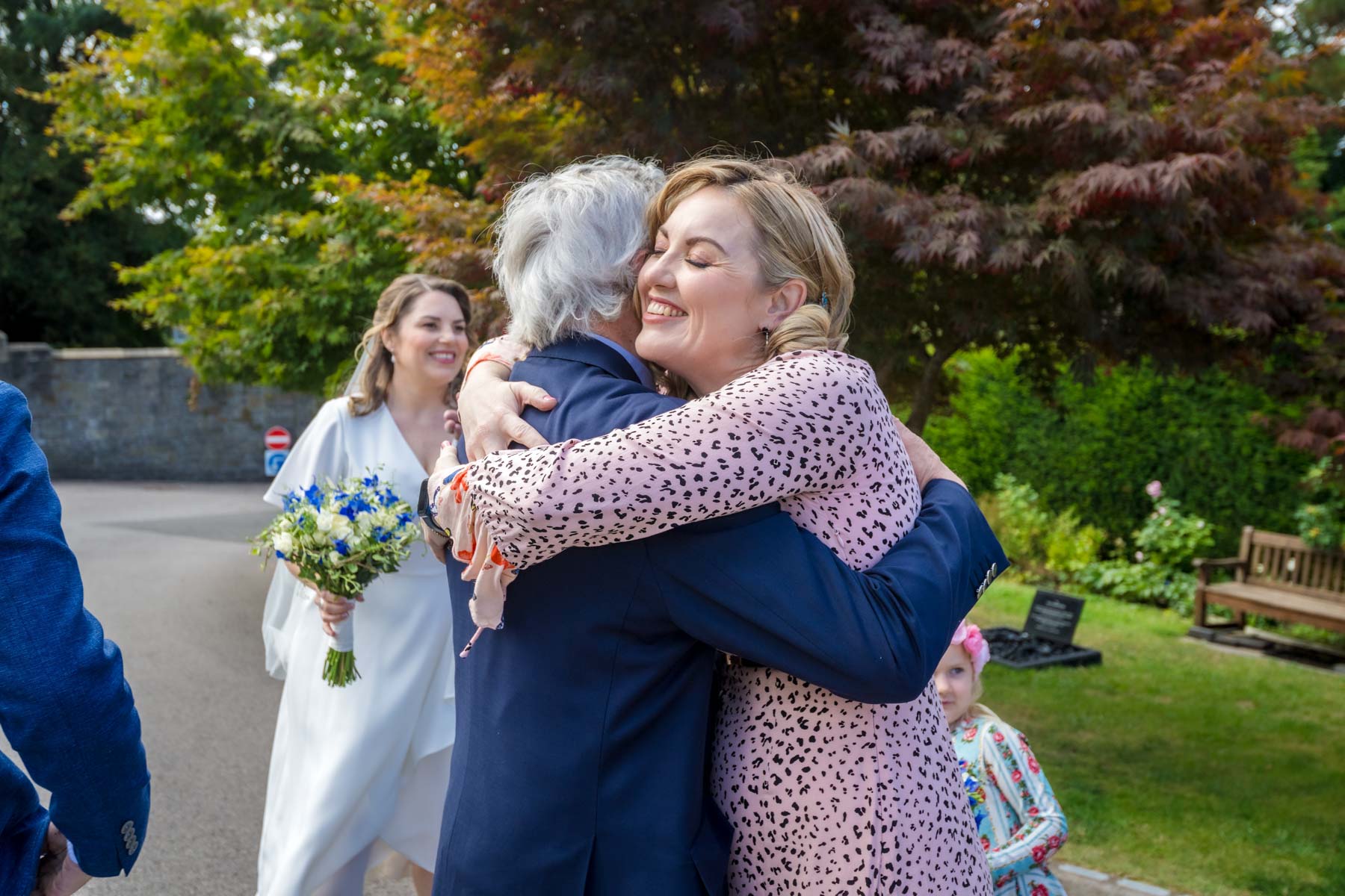 A wedding guest hugging a relative before a wedding at Insole Court