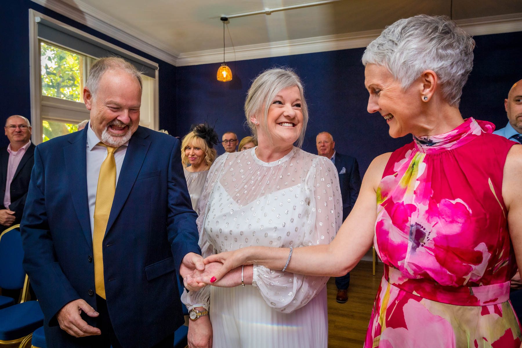 A friend places the bride's hand in the grooms to give her away
