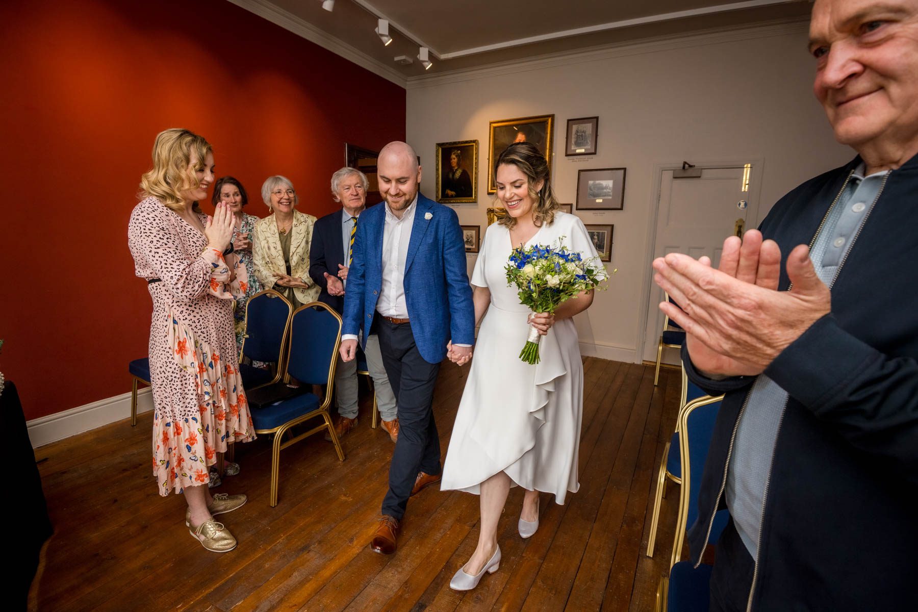 The Bride and Groom walking down the aisle of Insole Court as guests watch
