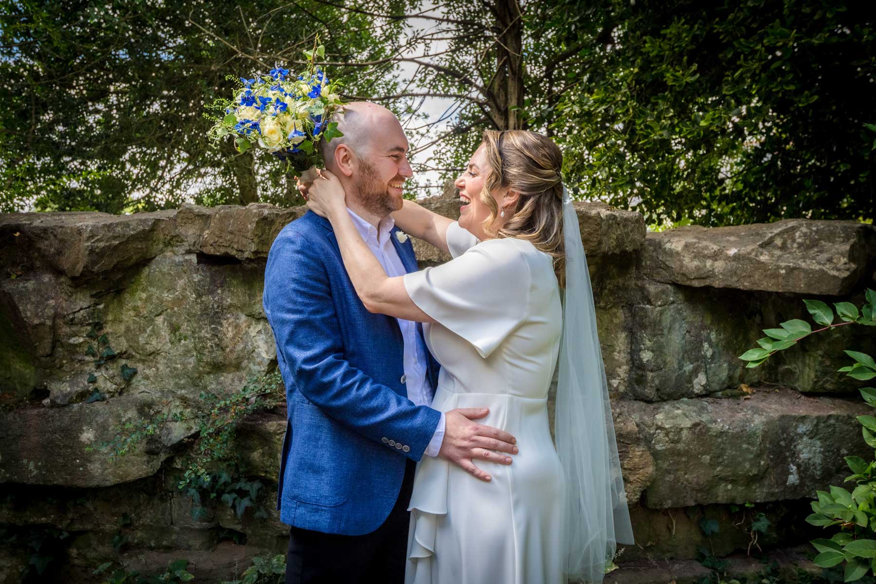Couple posing in front of rock wall at Insole Court